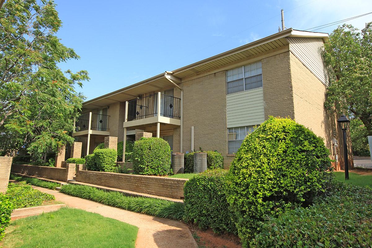 a large brick building with grass in front of a house