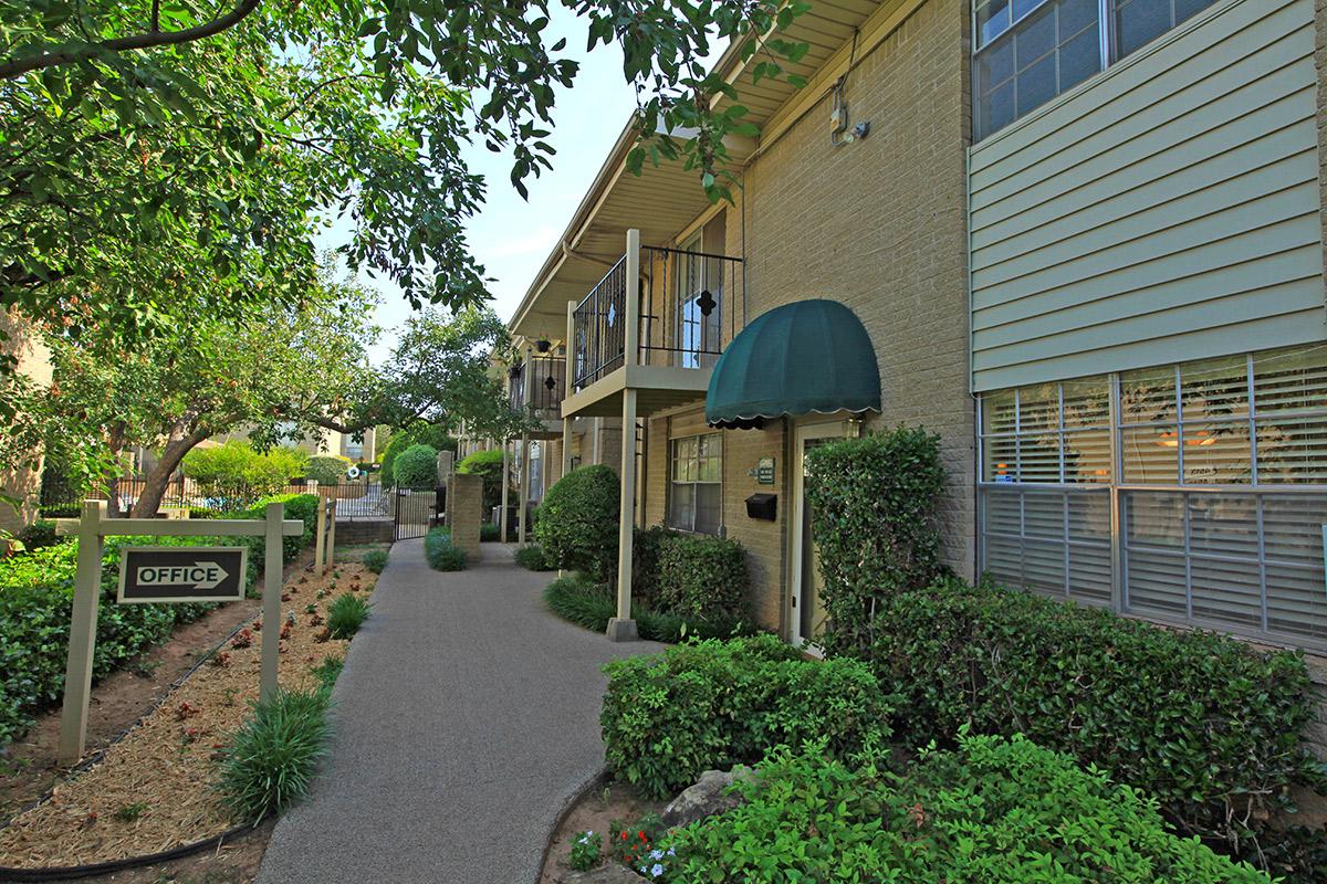 a house with bushes in front of a brick building