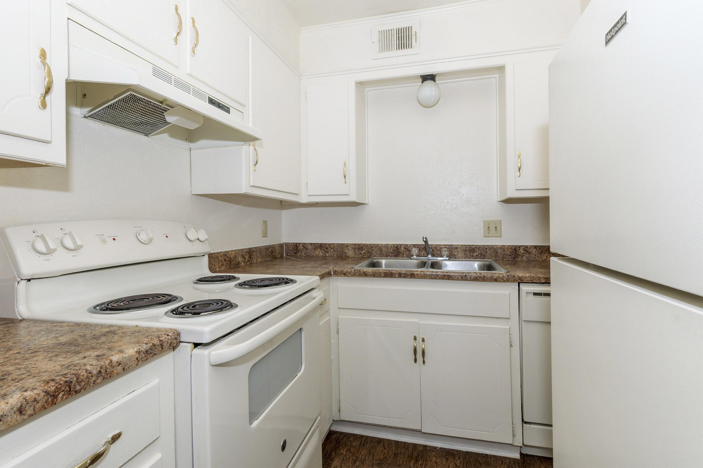 a white stove top oven sitting inside of a kitchen