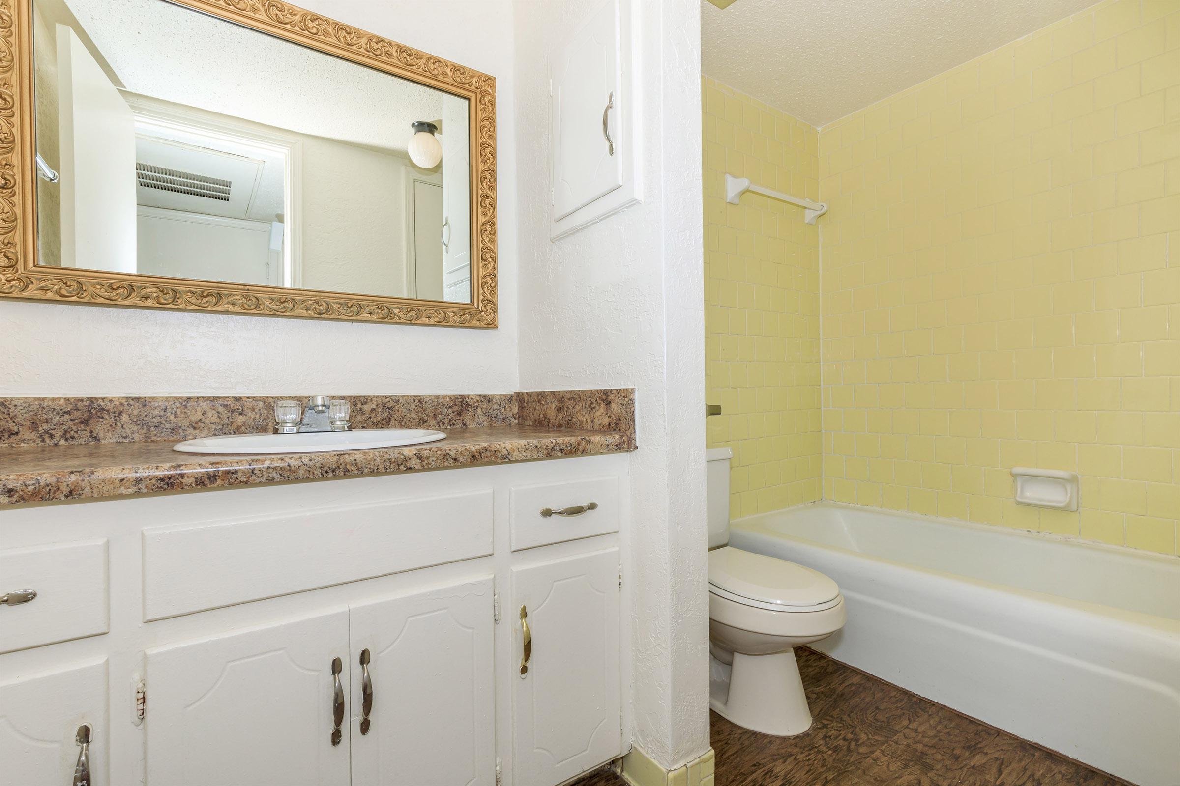 a white sink sitting under a mirror