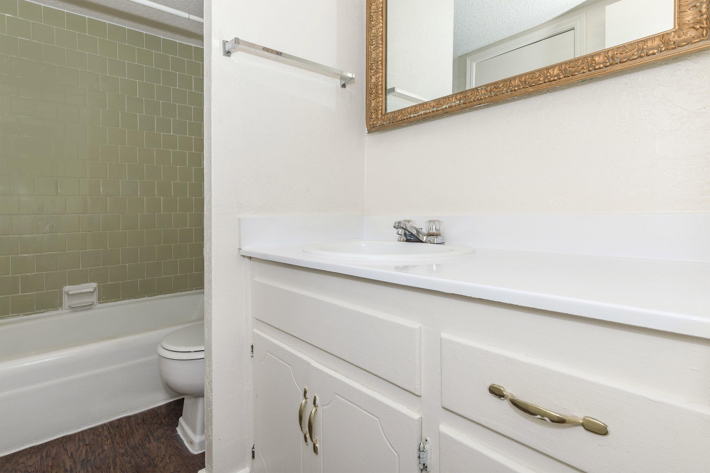 a white sink sitting under a mirror