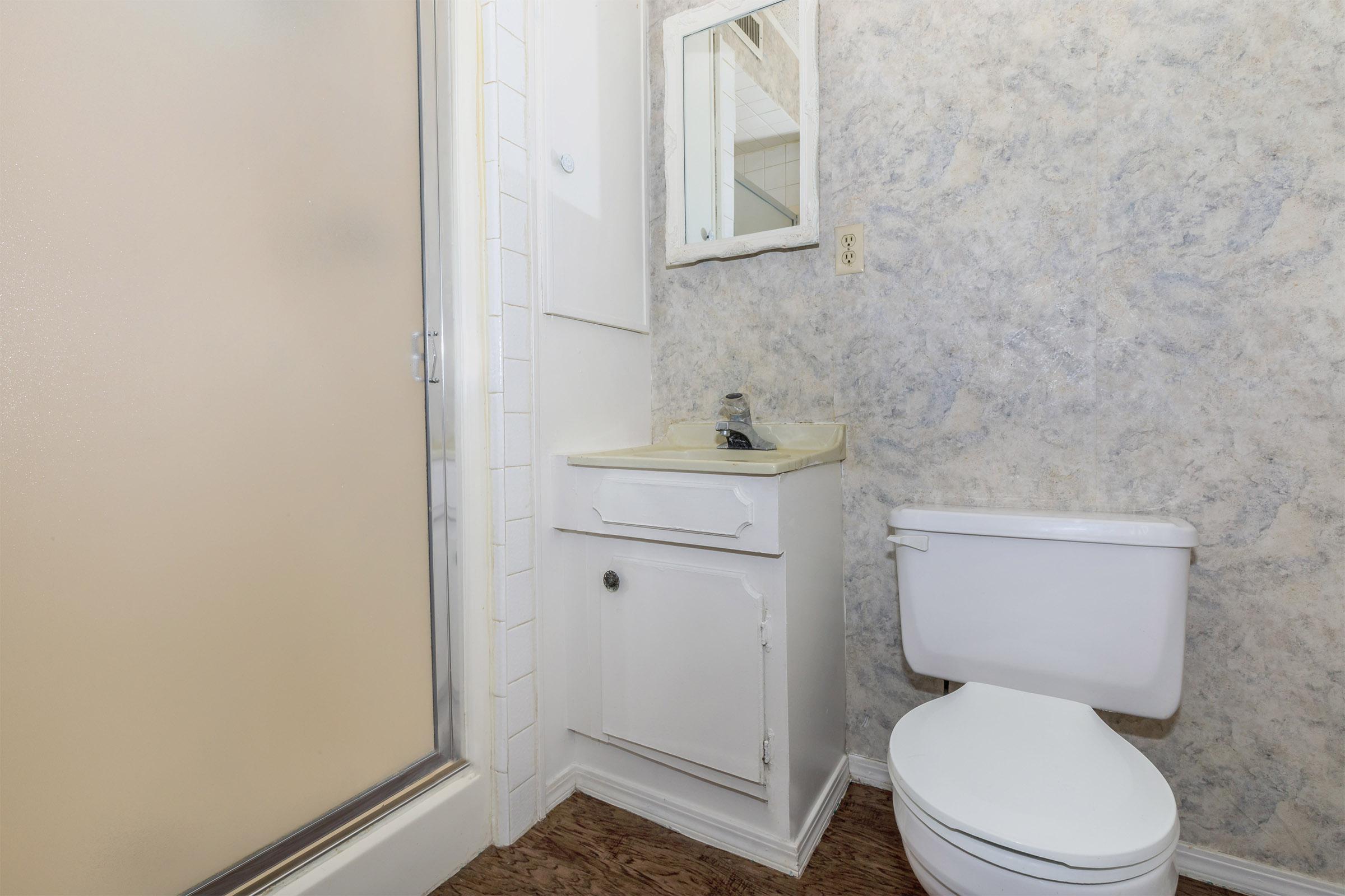 a white sink sitting under a mirror