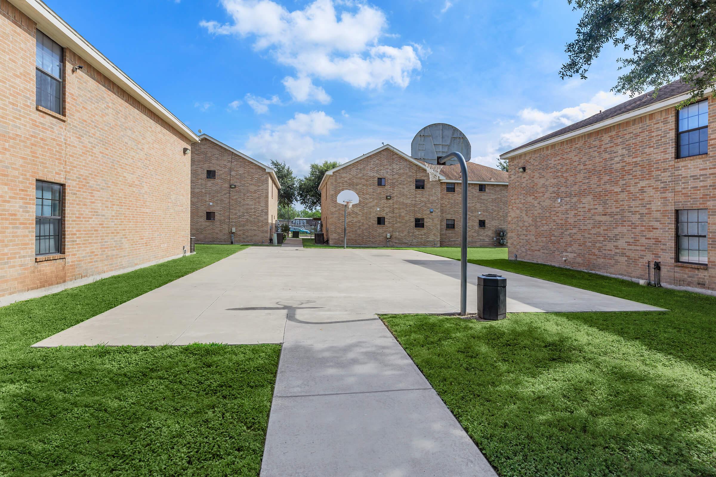 a large brick building with grass in front of a house