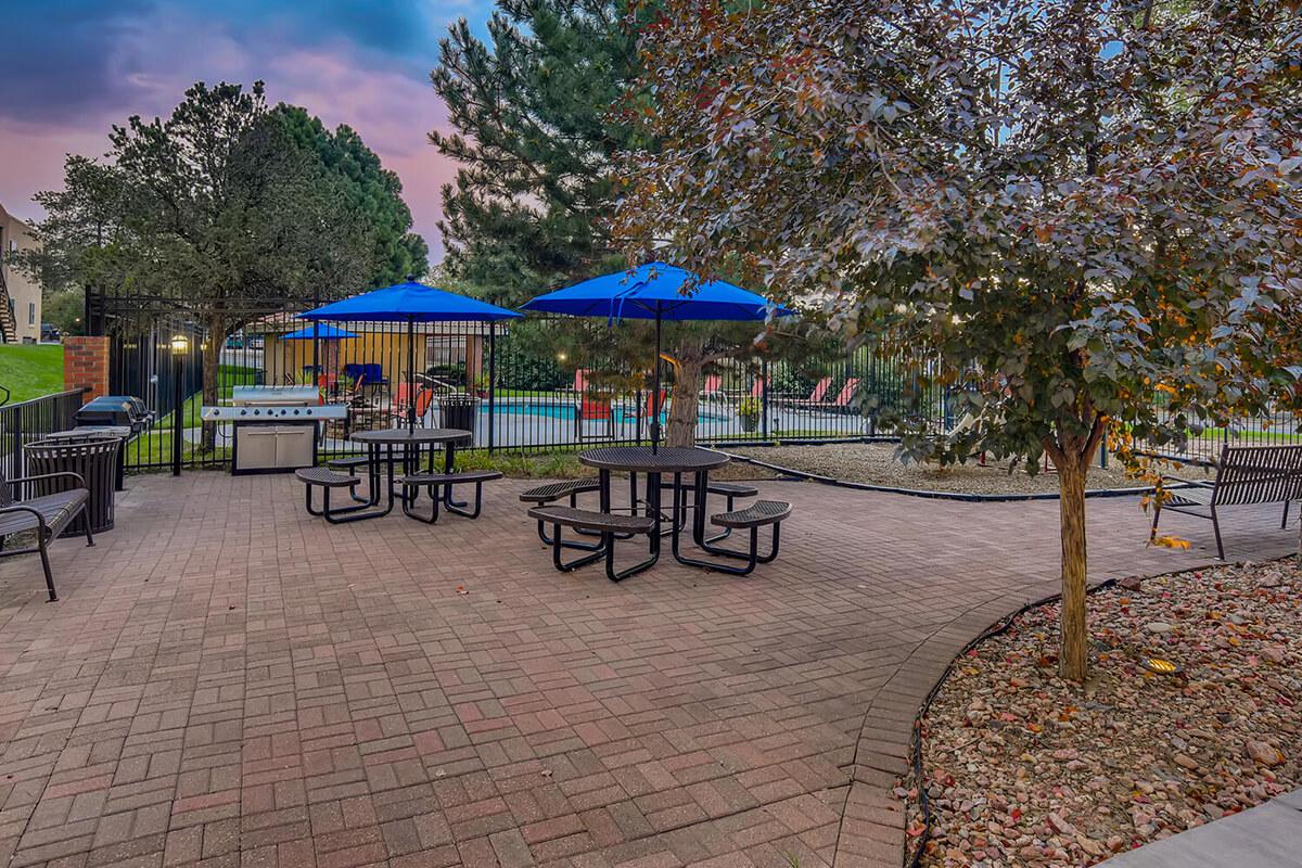 a group of lawn chairs sitting on top of a blue umbrella