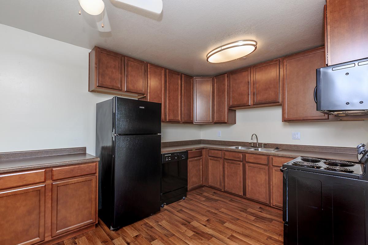 a large kitchen with stainless steel appliances and wooden cabinets