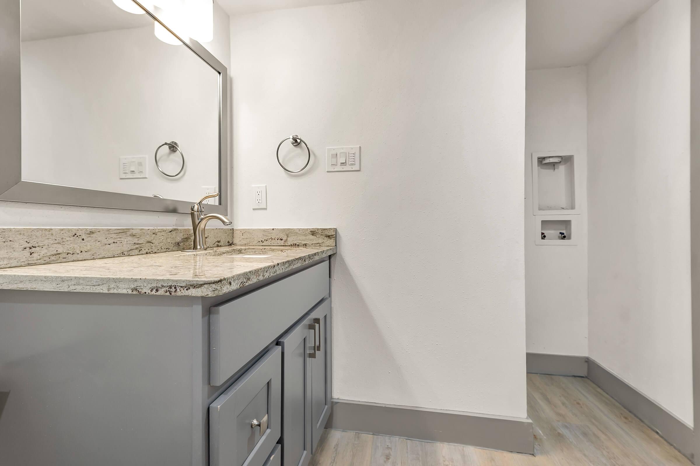 a kitchen with a sink and a mirror in a room