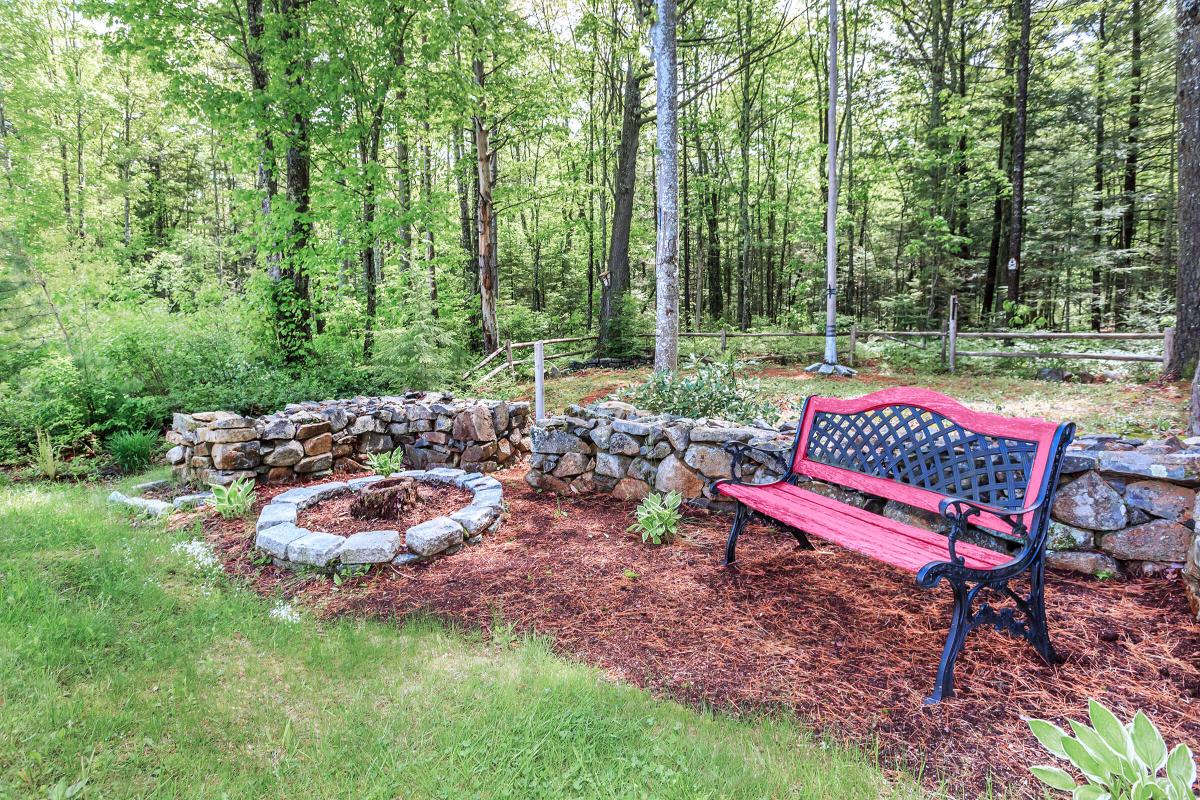 a wooden park bench sitting in the middle of a forest