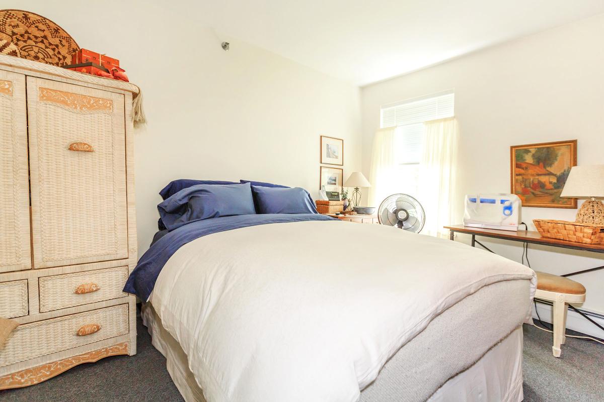 a bedroom with a bed and desk in a room