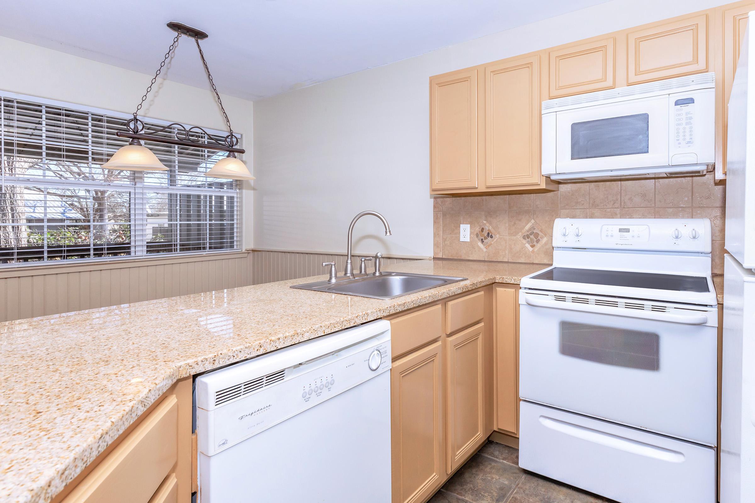 a stove top oven sitting inside of a kitchen