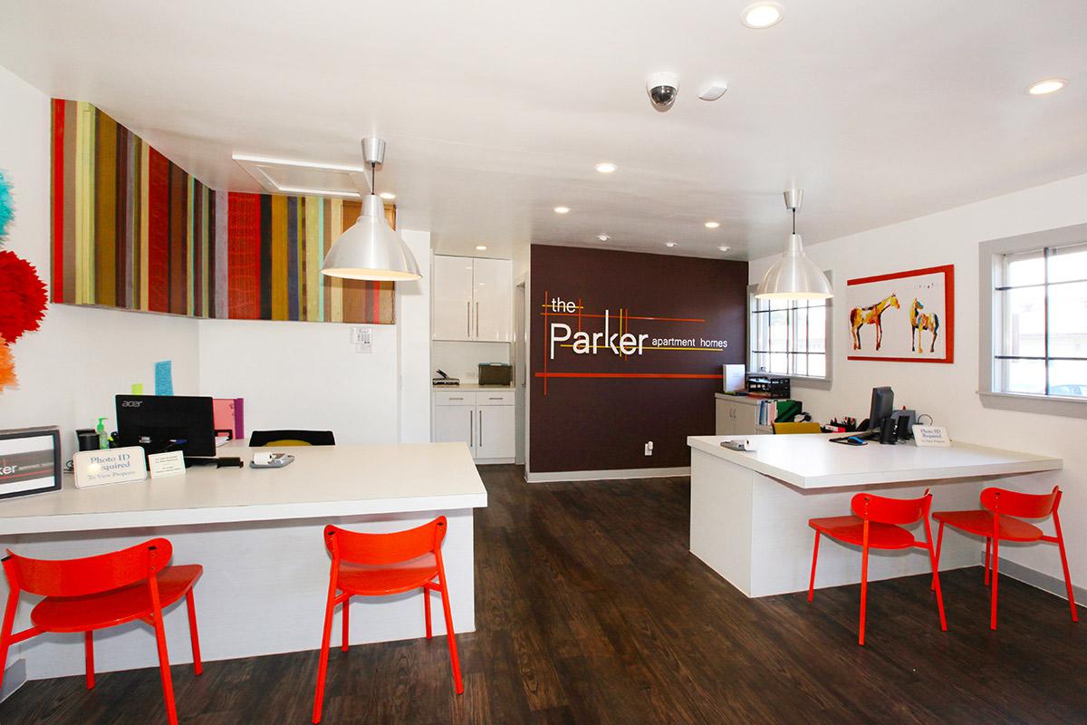 a large red chair in a living room filled with furniture and a table