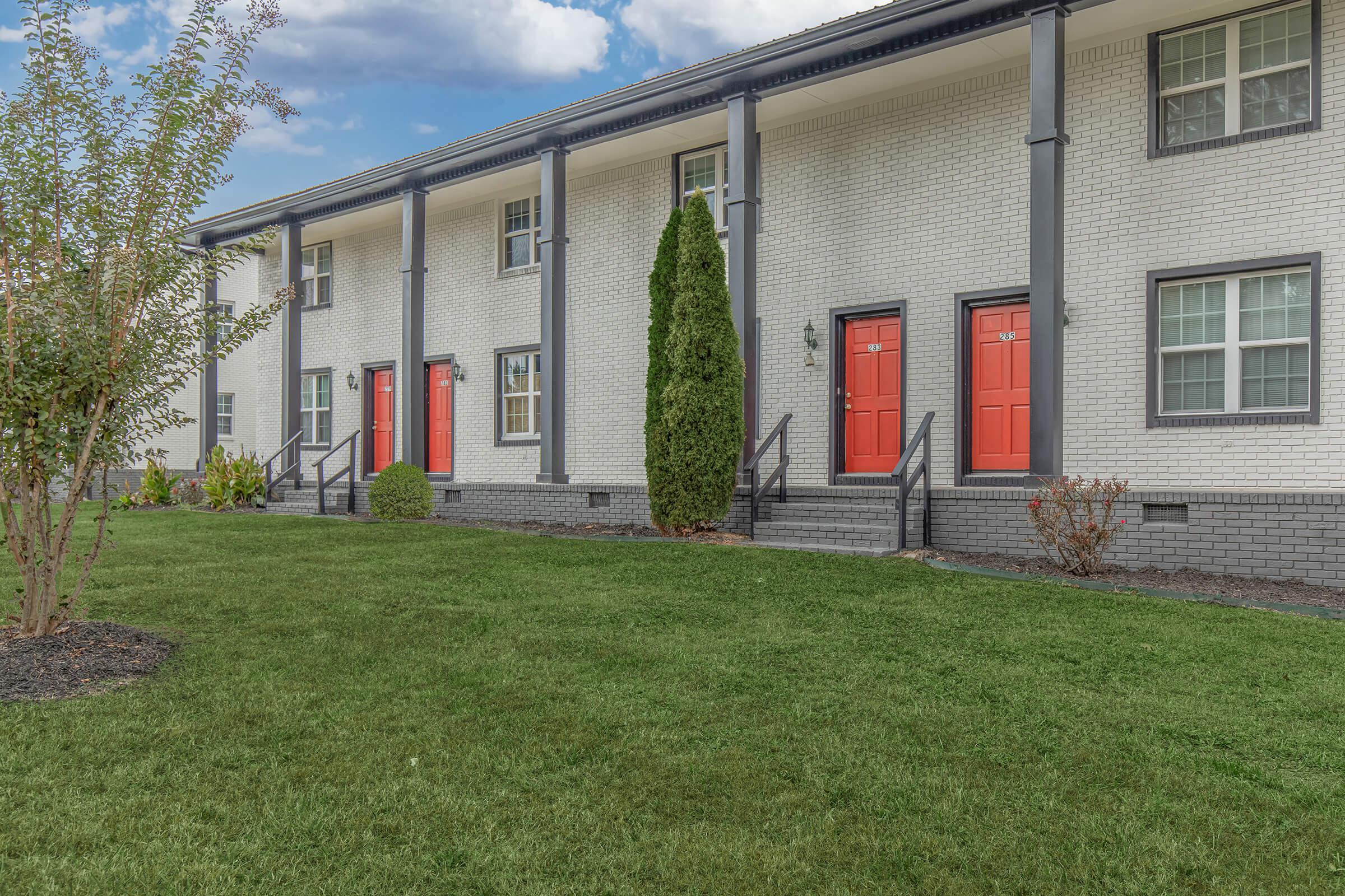 	The Elements44 Townhomes beautifully landscaped townhomes, grass, trees, bushes, orange front doors and windows