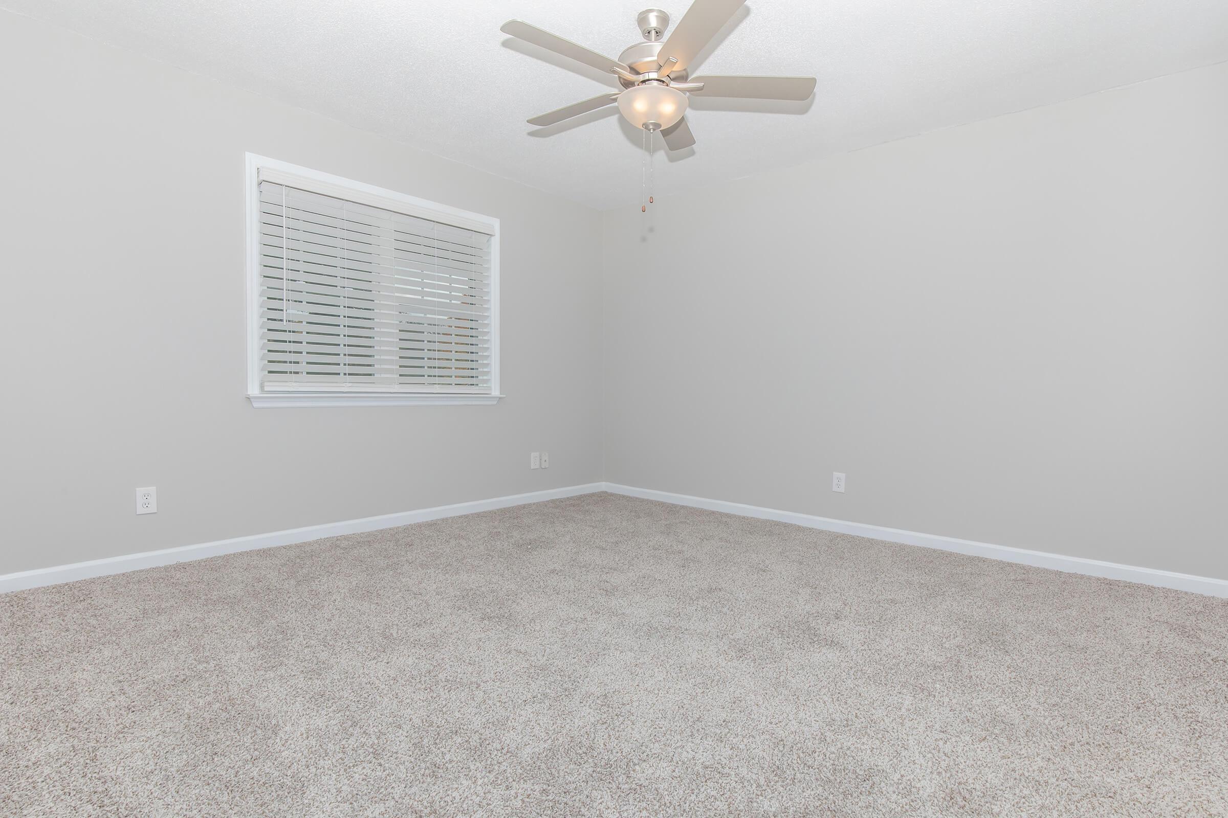 Another view of the Elements44 Townhomes bedroom showcasing its large room with ceiling fan and carpeted floor and the bedroom window