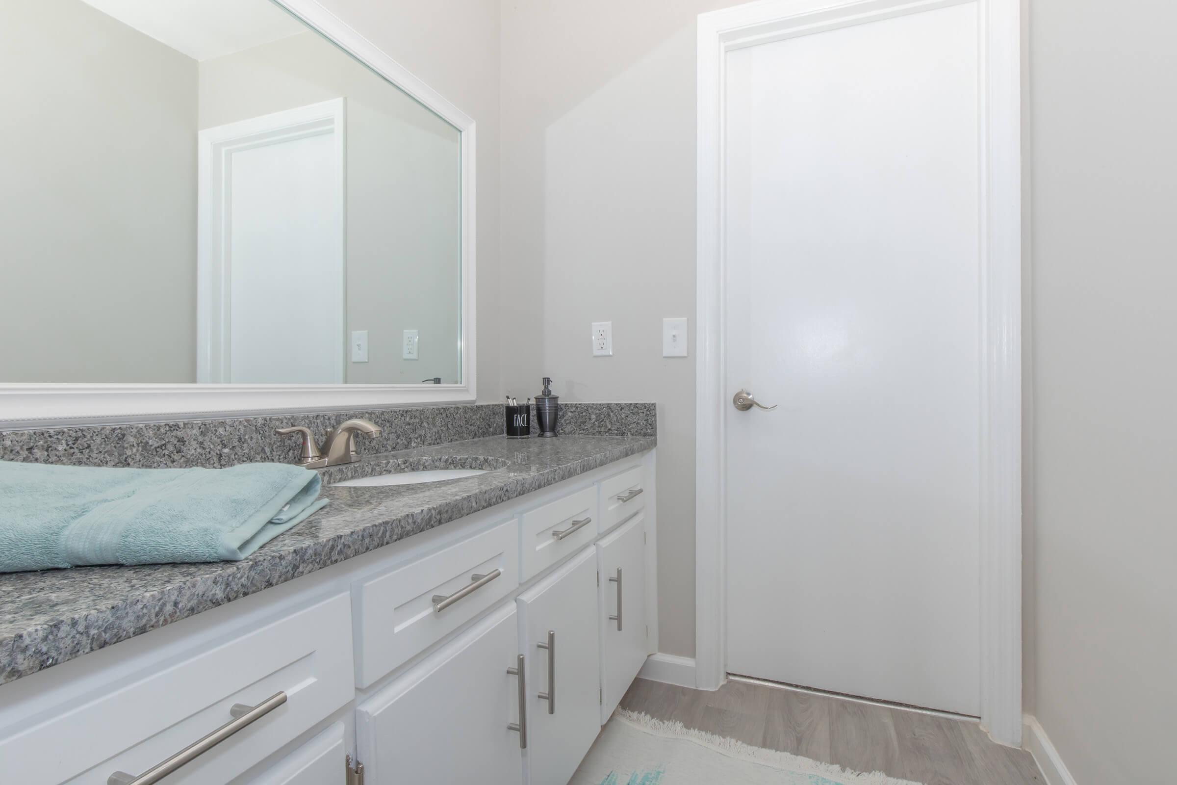 This is the bathroom sink, mirror, and door in the 2 Bed 1.5 Bath for Elements44 Townhomes