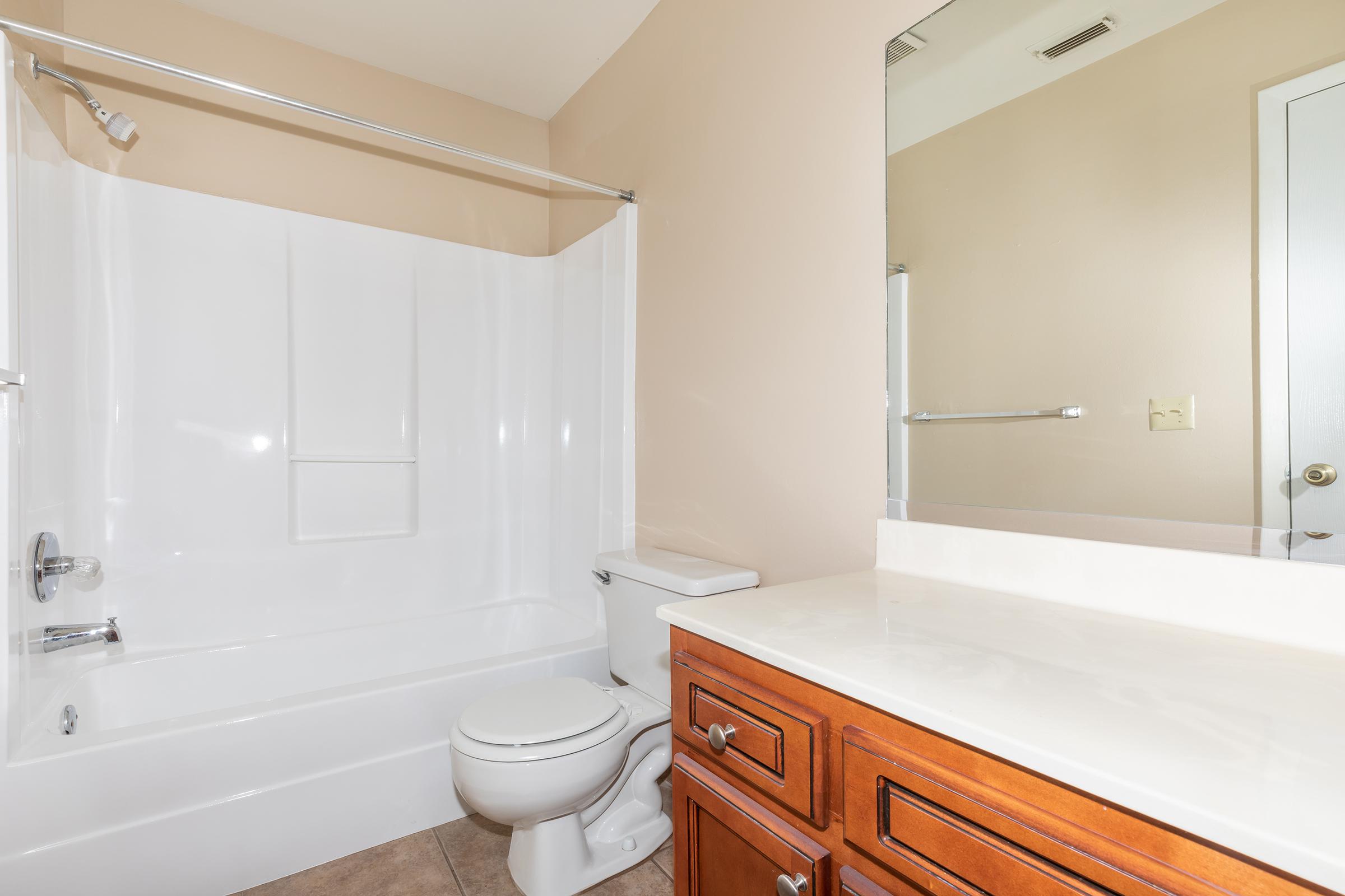 a large white tub next to a shower