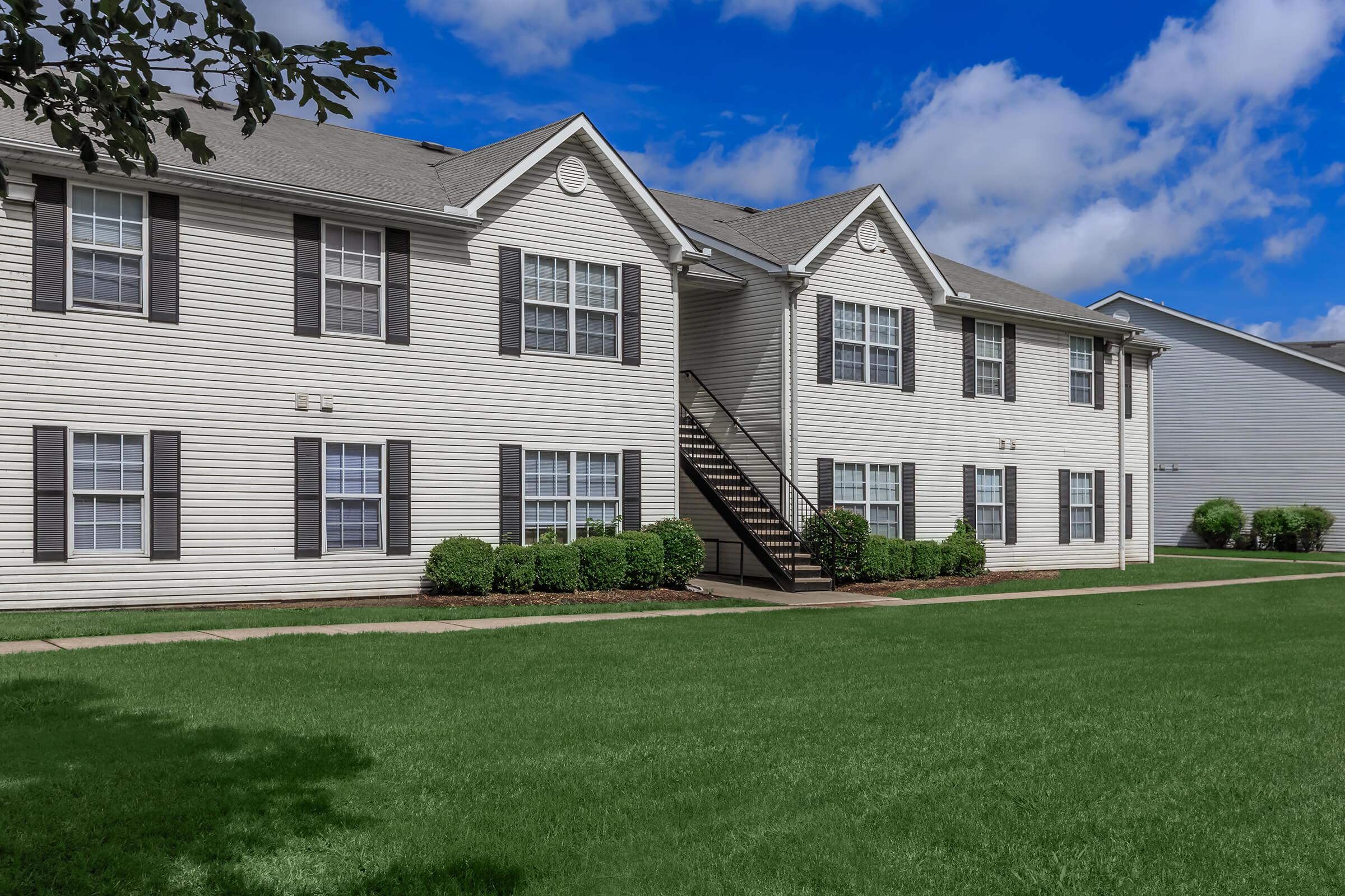 a large brick building with grass in front of a house