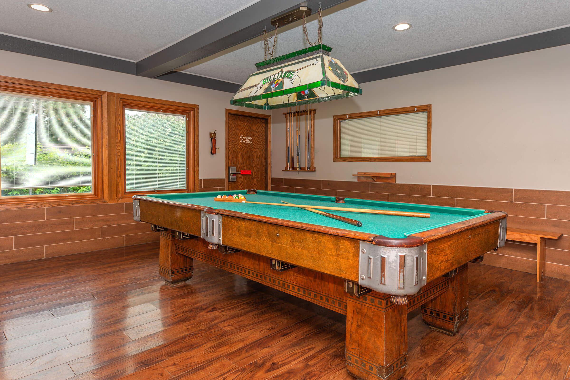 Billiards room with pool table and seating at Homewood Manor Apartments in Moline, IL
