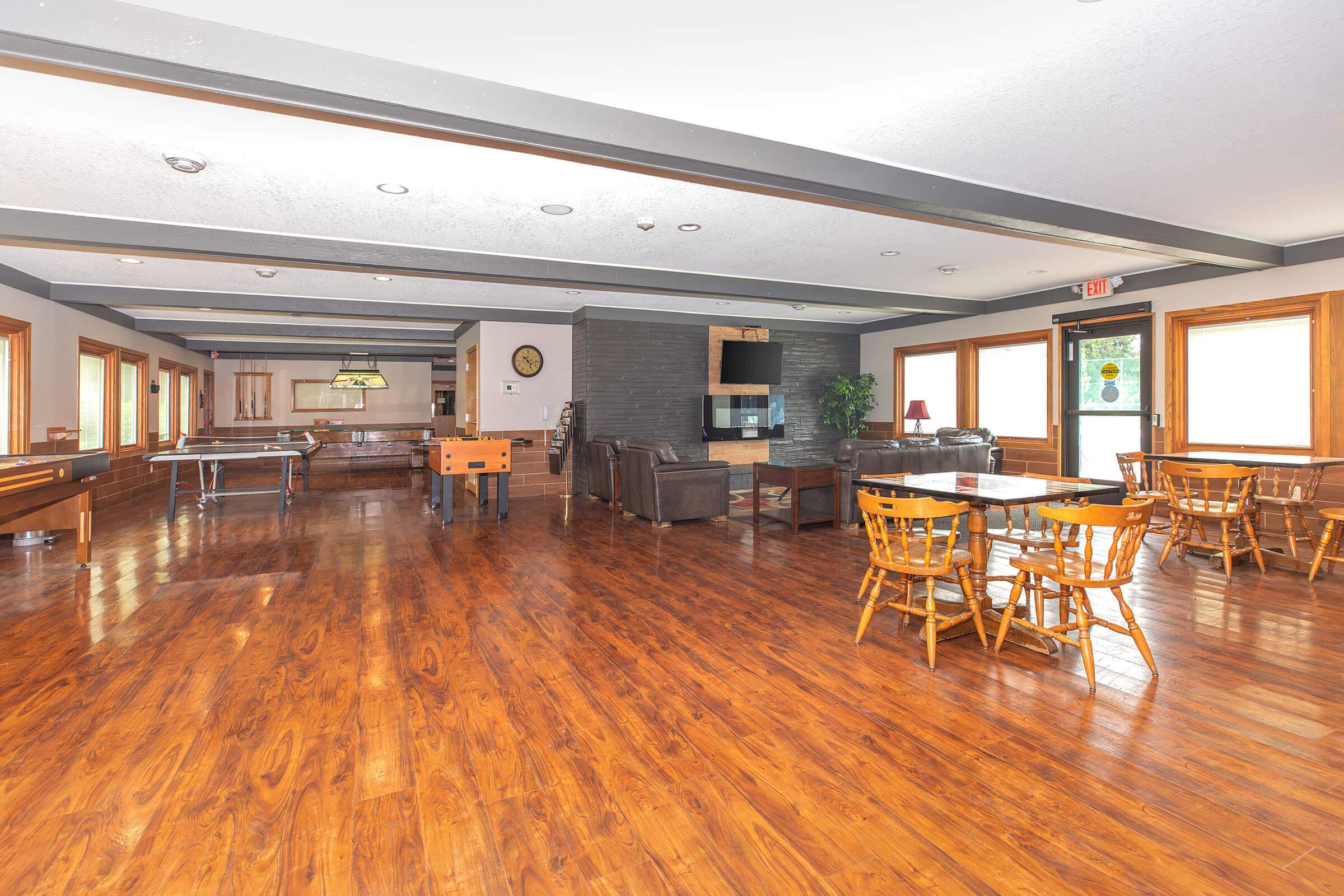 Large community room with hardwood floors at Homewood Manor Apartments in Moline, IL
