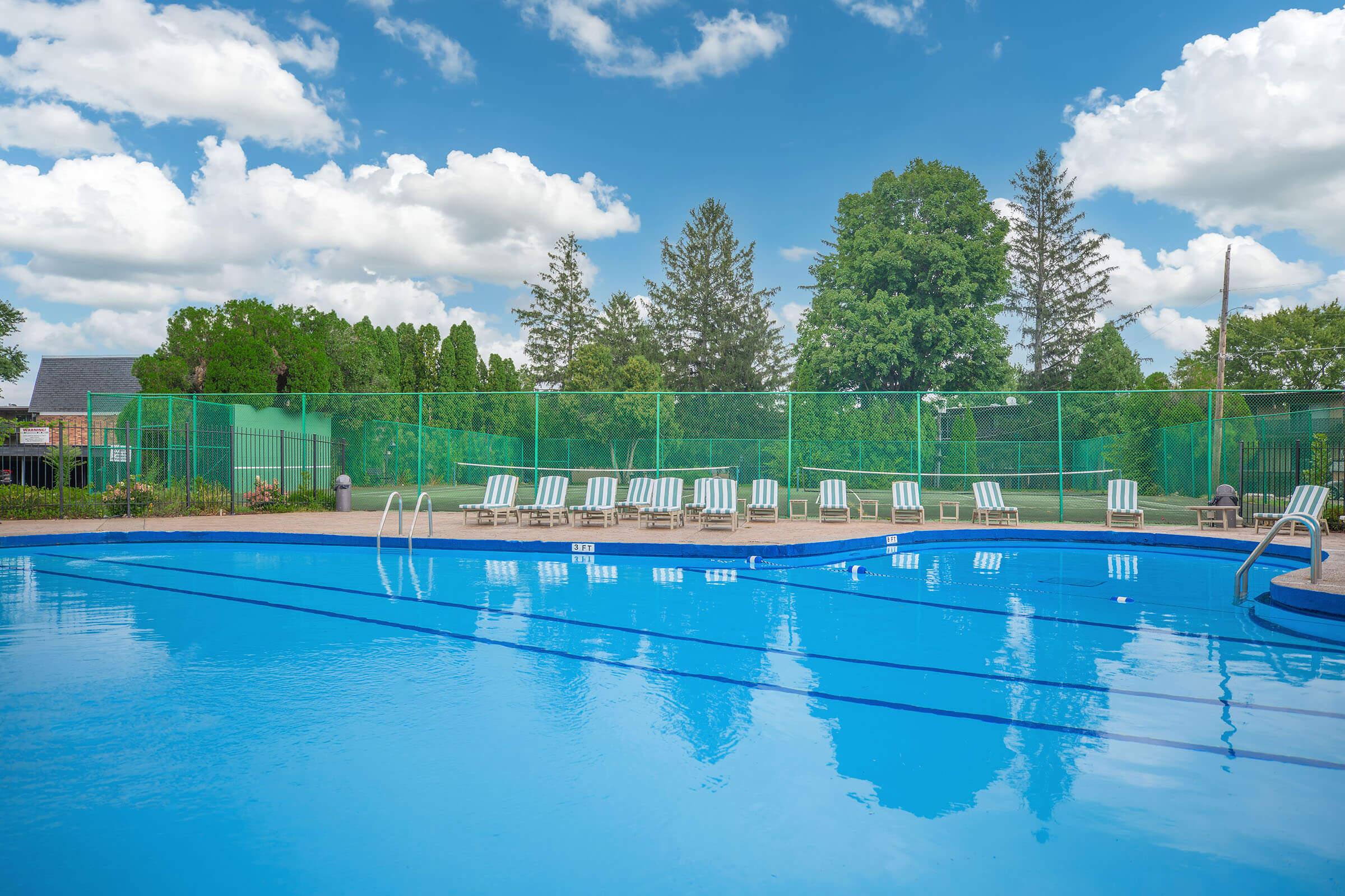 Sparkling outdoor swimming pool with lounge chairs at Homewood Manor Apartments in Moline, IL