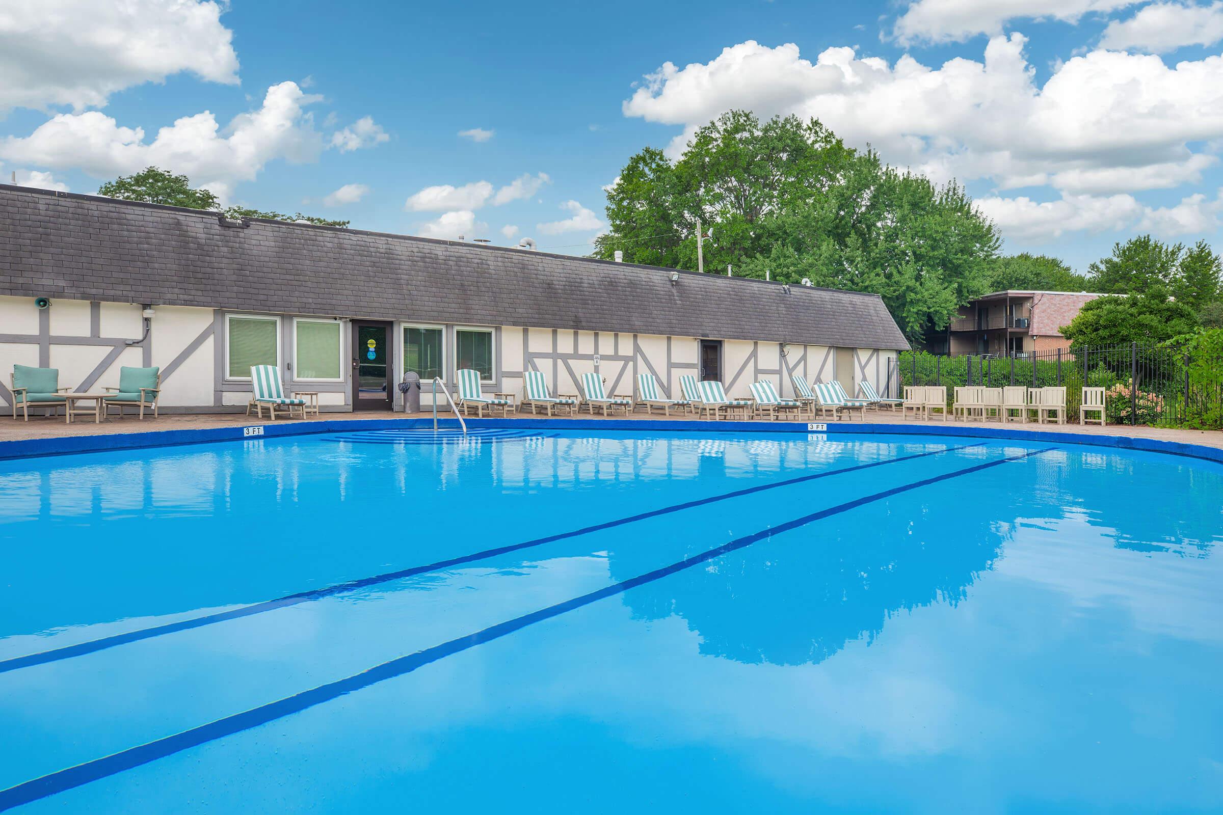 Large outdoor pool with sundeck and lounge area at Homewood Manor Apartments in Moline, IL