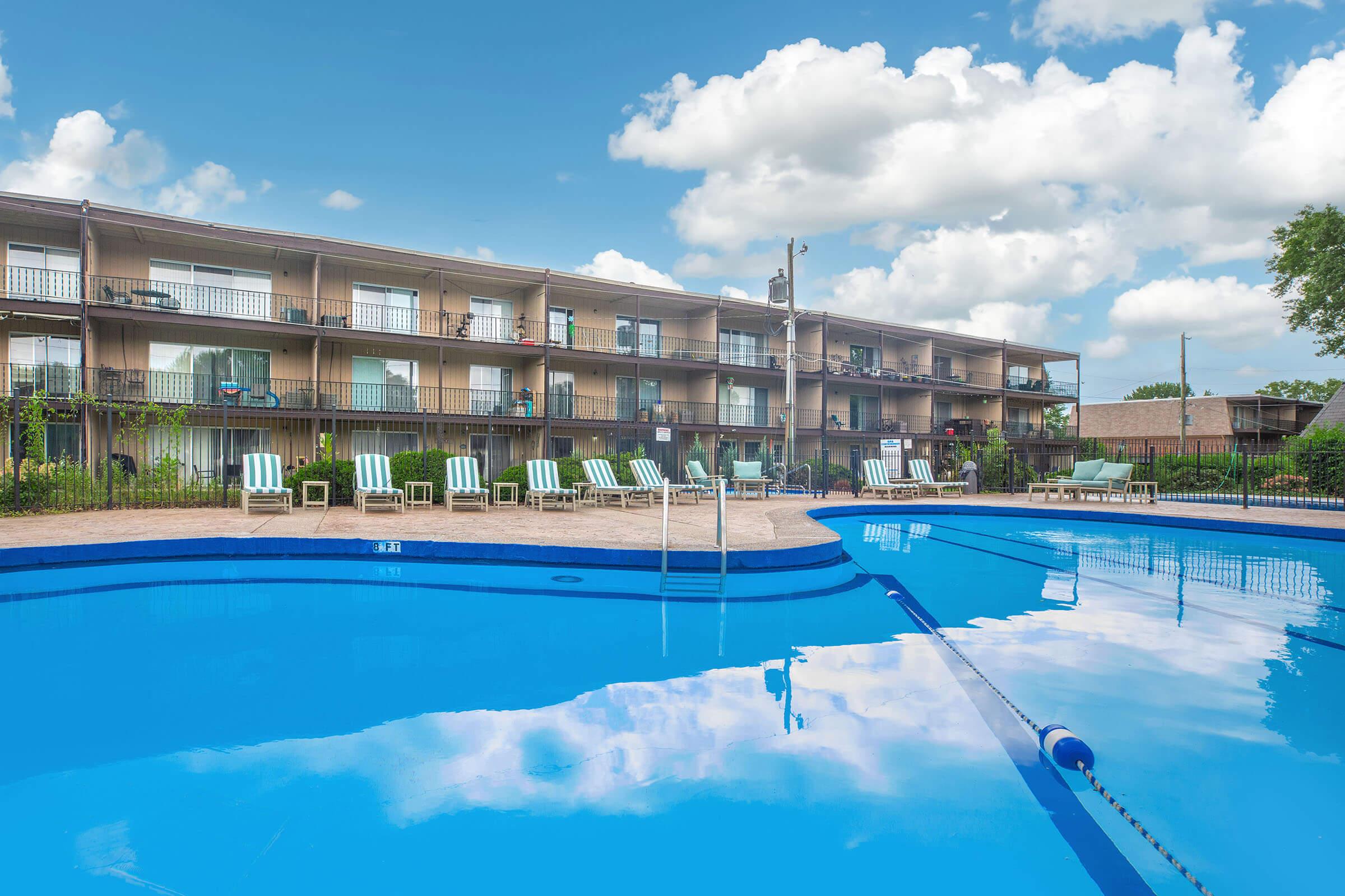 Poolside view of apartments with balconies at Homewood Manor Apartments in Moline, IL