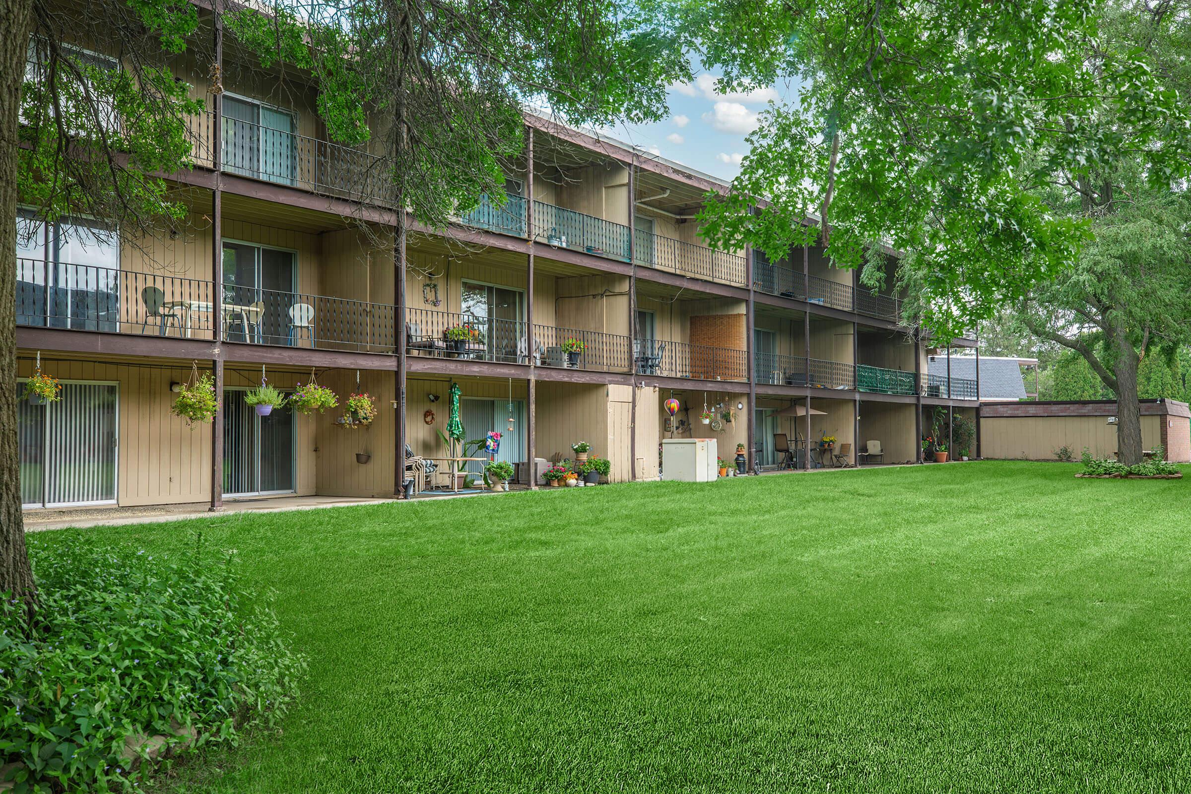 Spacious green courtyard with apartment balconies at Homewood Manor Apartments in Moline, IL