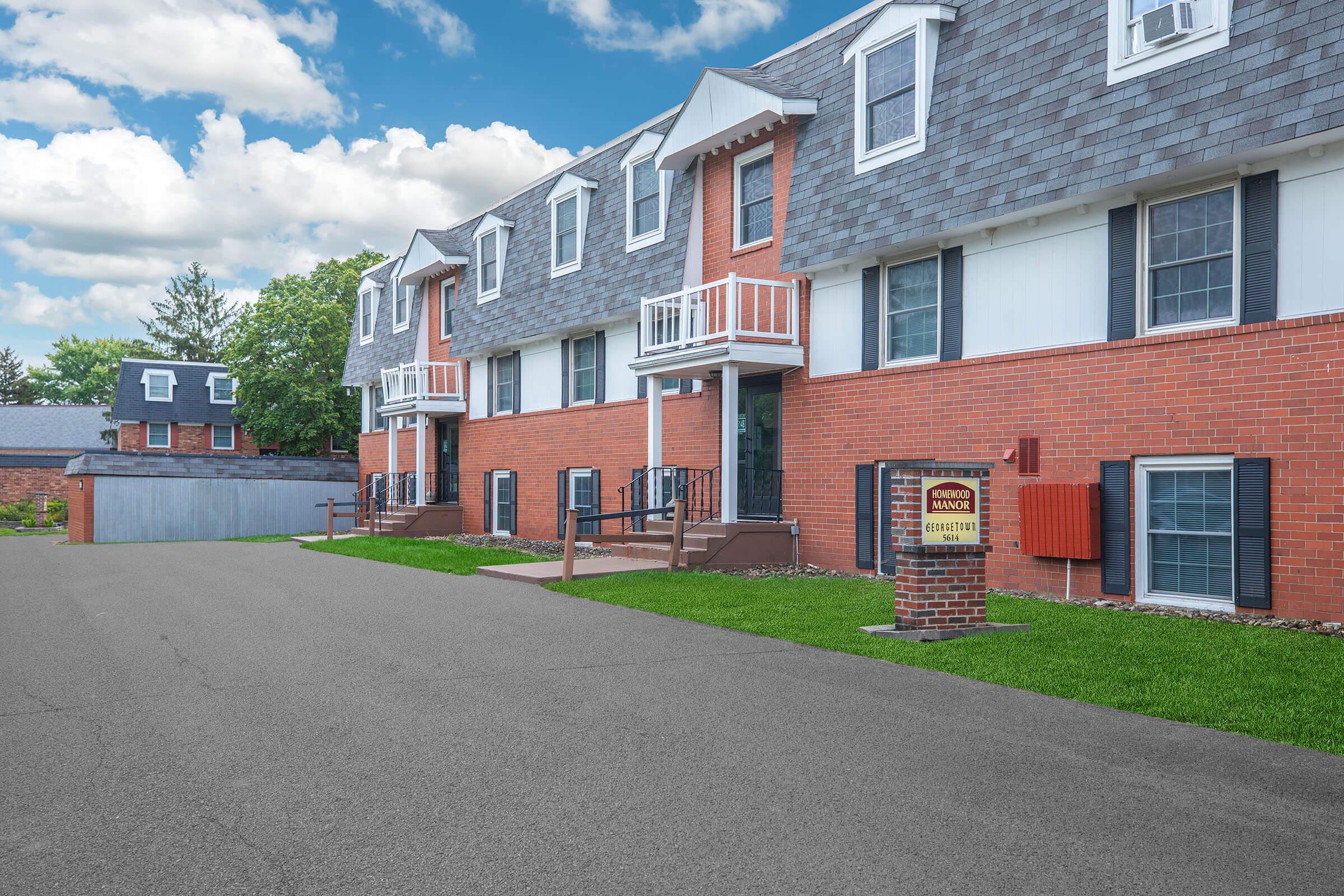 Parking lot and exterior view of apartments at Homewood Manor Apartments in Moline, IL