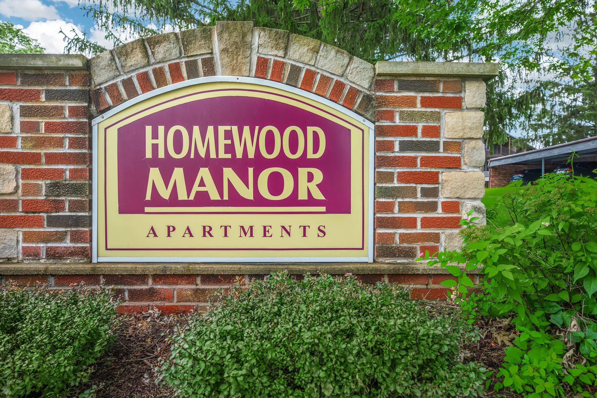Homewood Manor Apartments entrance sign surrounded by landscaping in Moline, IL