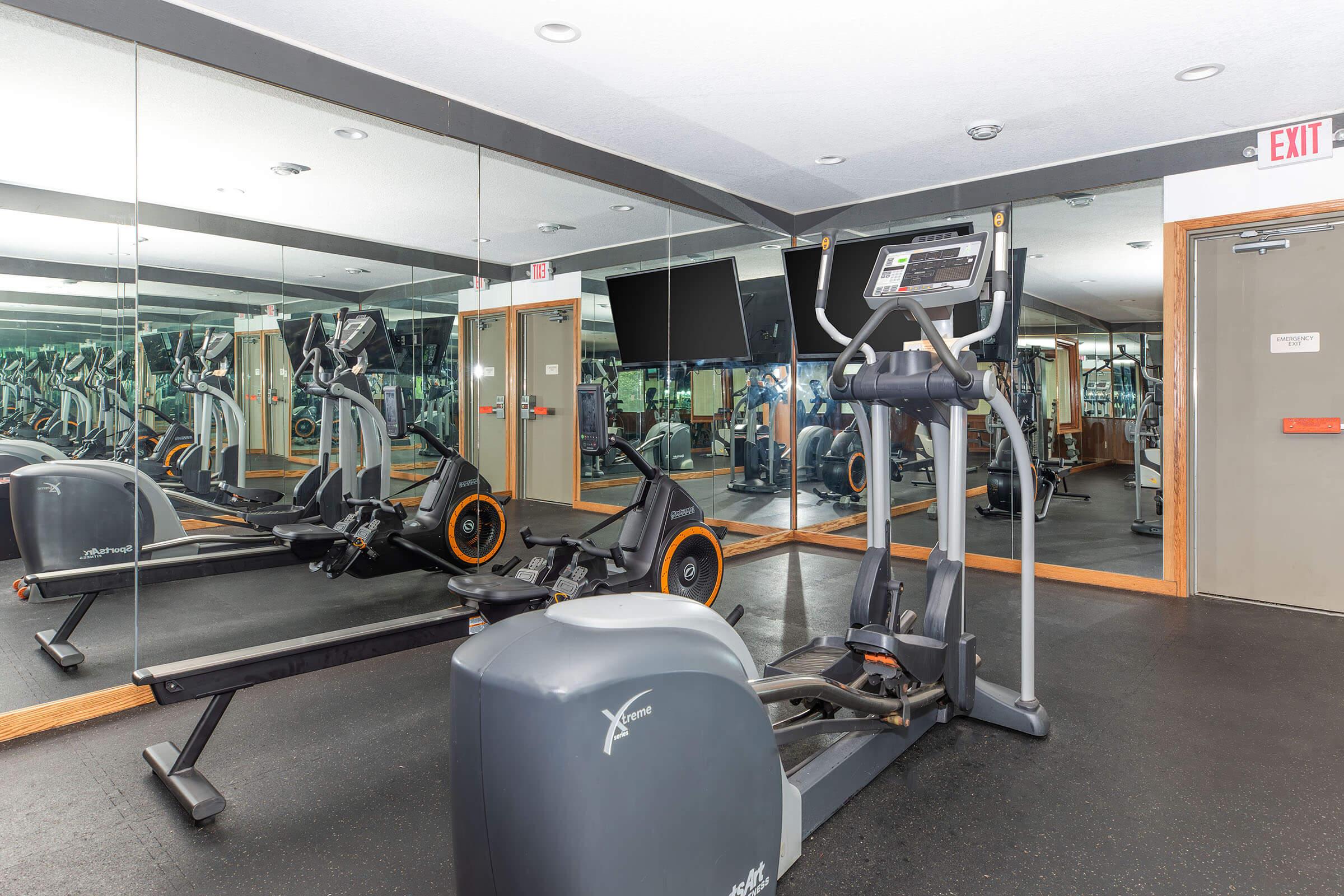 Fully equipped fitness center with cardio and strength machines at Homewood Manor Apartments in Moline, IL