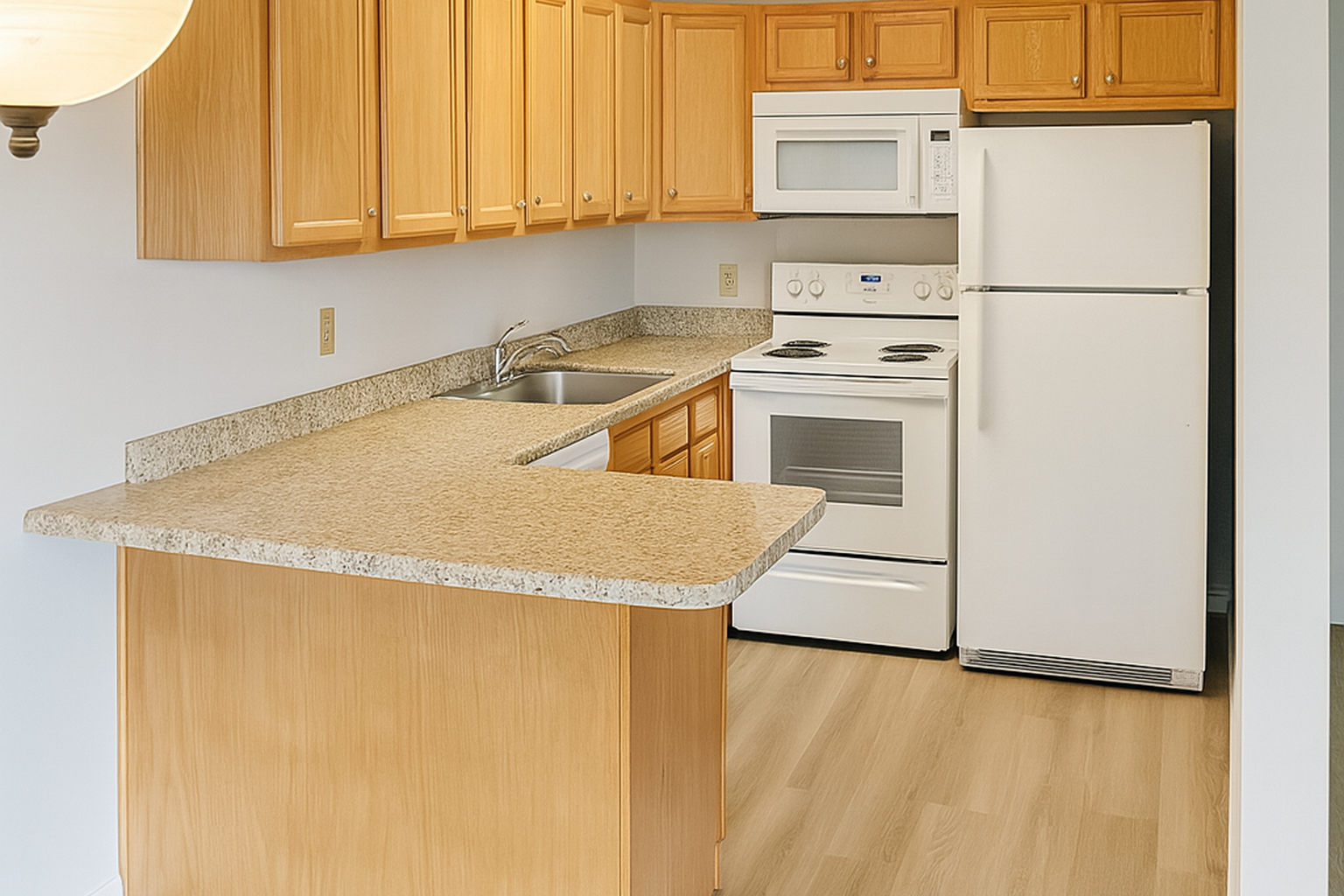 A modern kitchen featuring light wooden cabinets, a granite countertop, a stainless steel sink, a stove with an oven, a microwave, and a white refrigerator. The floor has a wood-like finish, creating a warm and inviting space. Bright lighting enhances the open layout.
