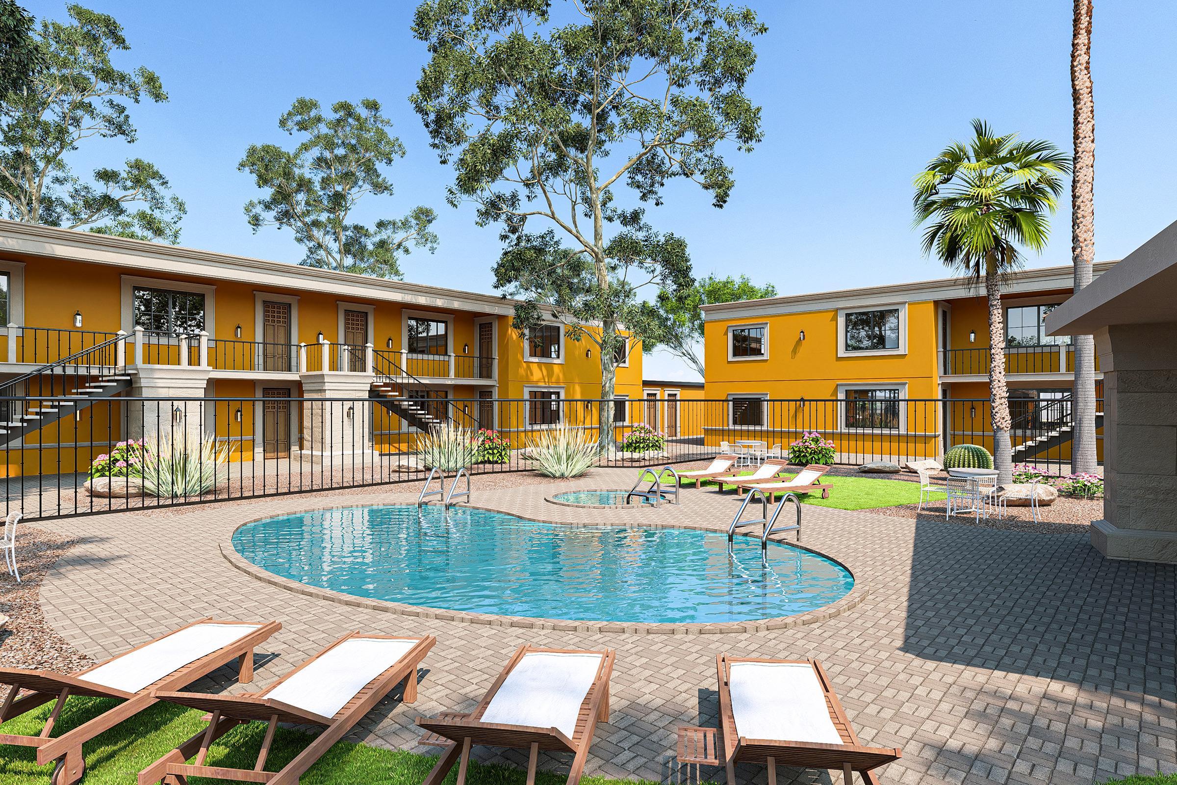 A sunny courtyard featuring a swimming pool surrounded by lounge chairs. Two-story yellow buildings frame the area, with landscaped greenery and palm trees adding to the relaxing atmosphere. Thespace is designed for leisure and community interaction, ideal for residents and visitors alike.