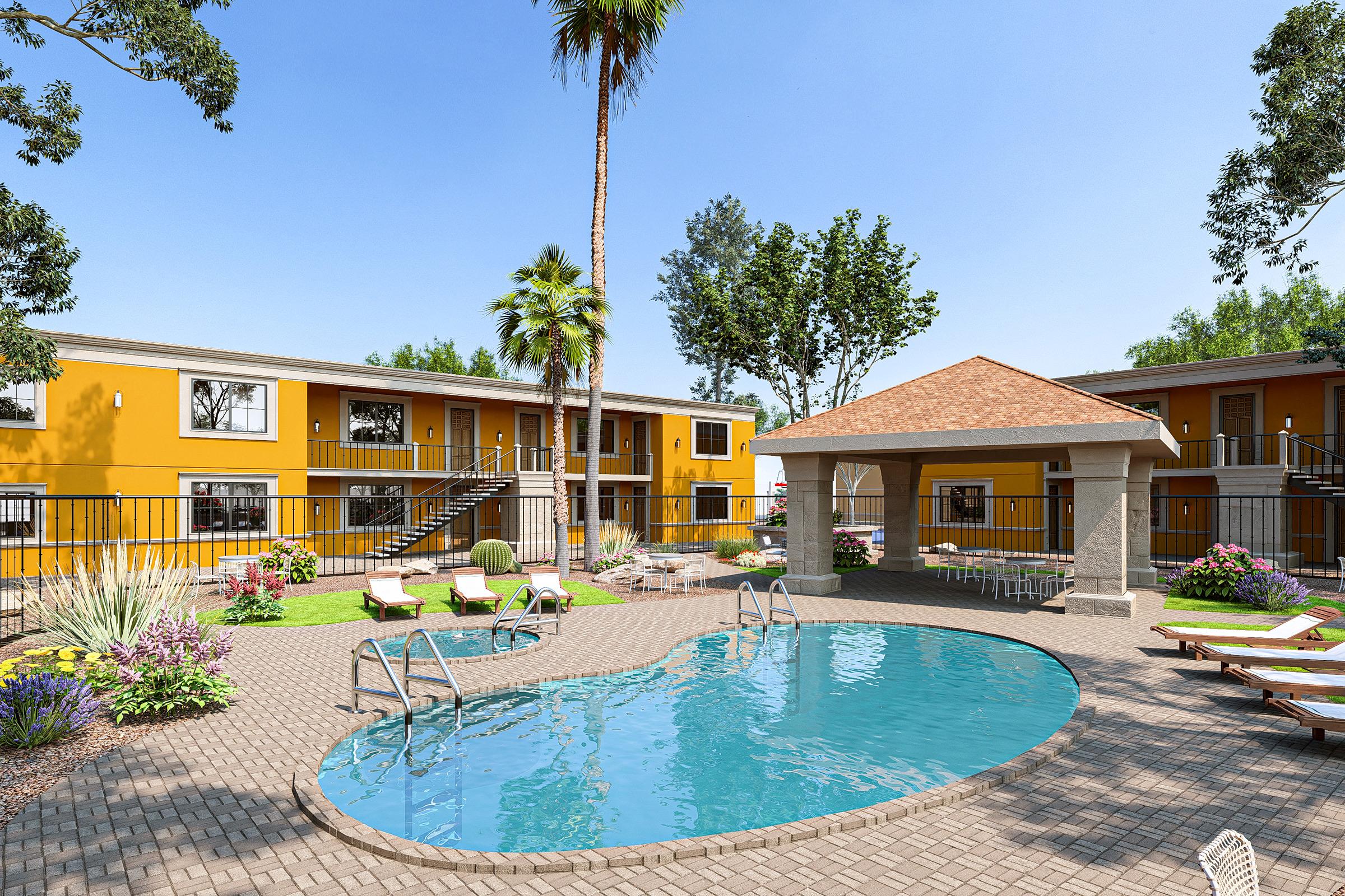 A sunny outdoor pool area surrounded by lush greenery, with palm trees and colorful flowers. The pool features lounge chairs and a shaded gazebo nearby, while yellow and white buildings with balconies create a welcoming atmosphere. It's a bright day with clear blue skies.