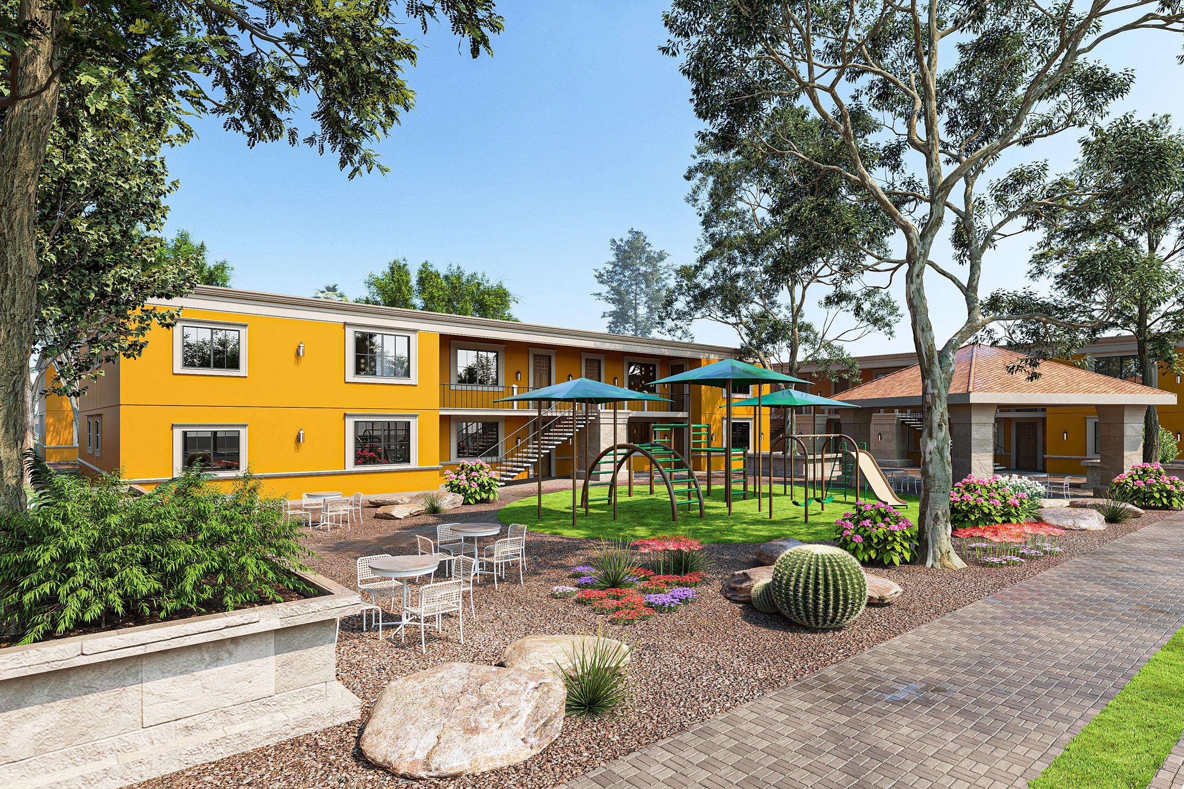 A vibrant outdoor area featuring a yellow building, playground equipment, and landscaped gardens with colorful flower beds. There are also stone pathways, seating areas with tables and chairs, and large trees providing shade, creating an inviting environment for relaxation and play.