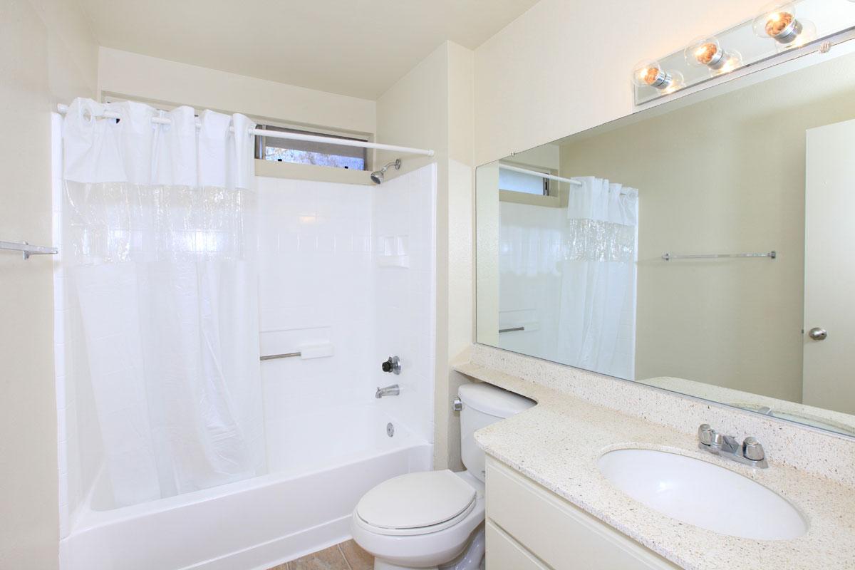 Bathroom with open white shower curtain