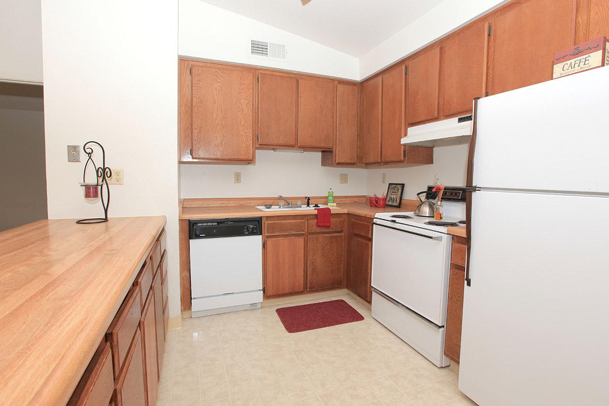 a kitchen with a stove refrigerator and wooden cabinets