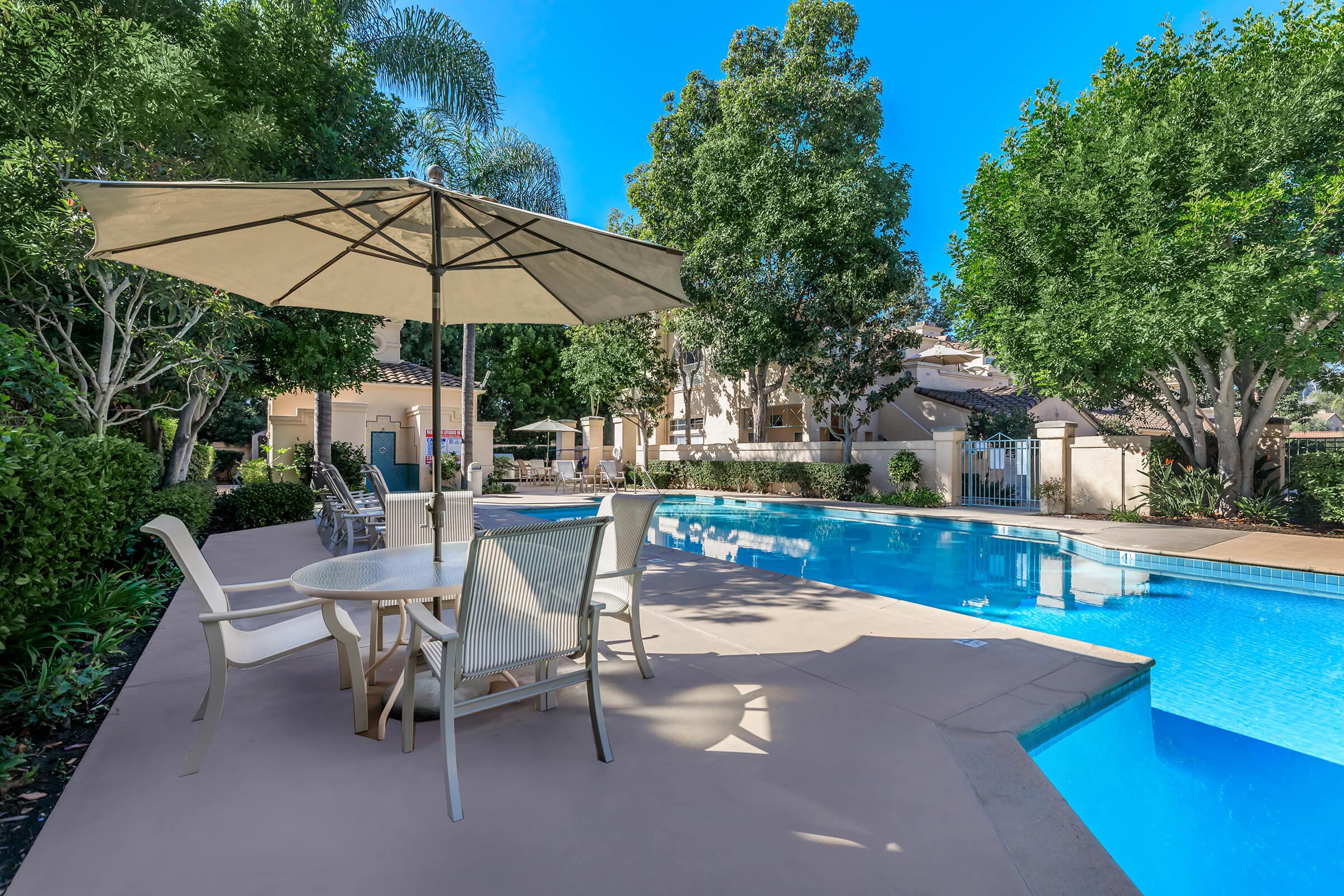 a couple of lawn chairs sitting next to a pool of water