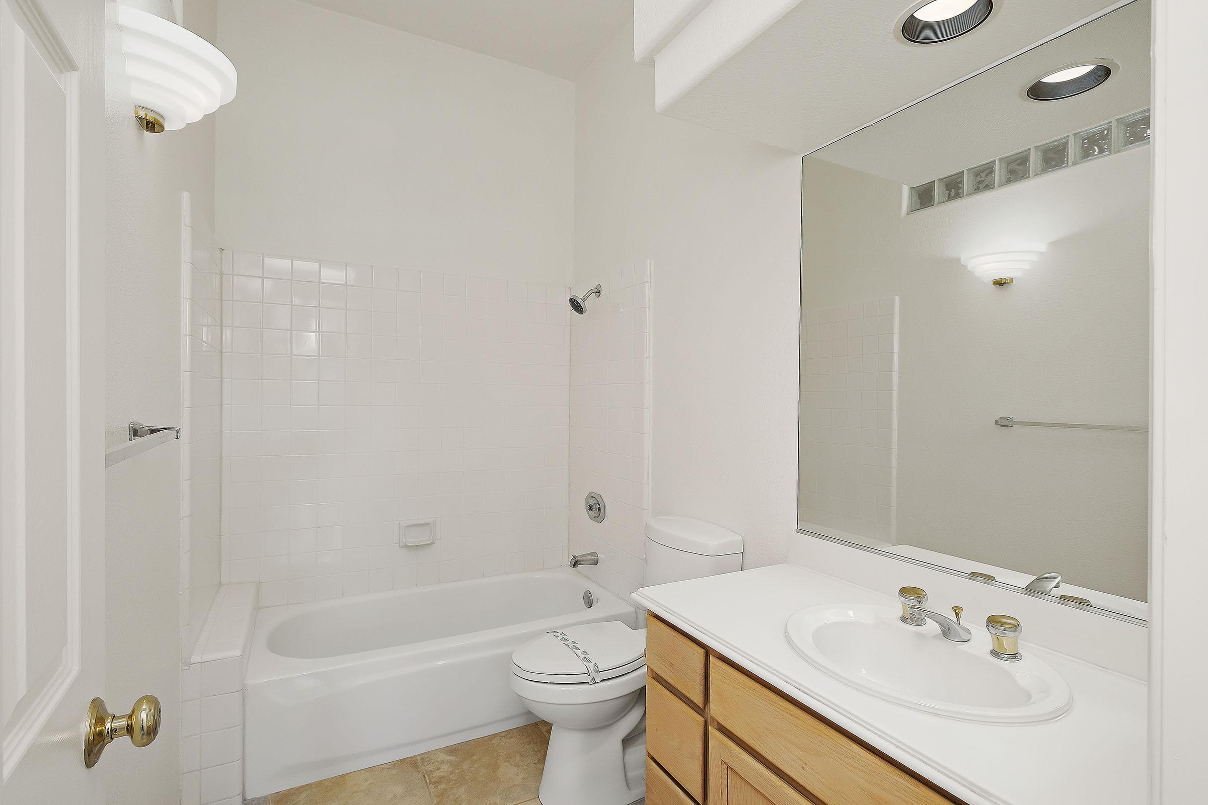 a white sink sitting next to a shower