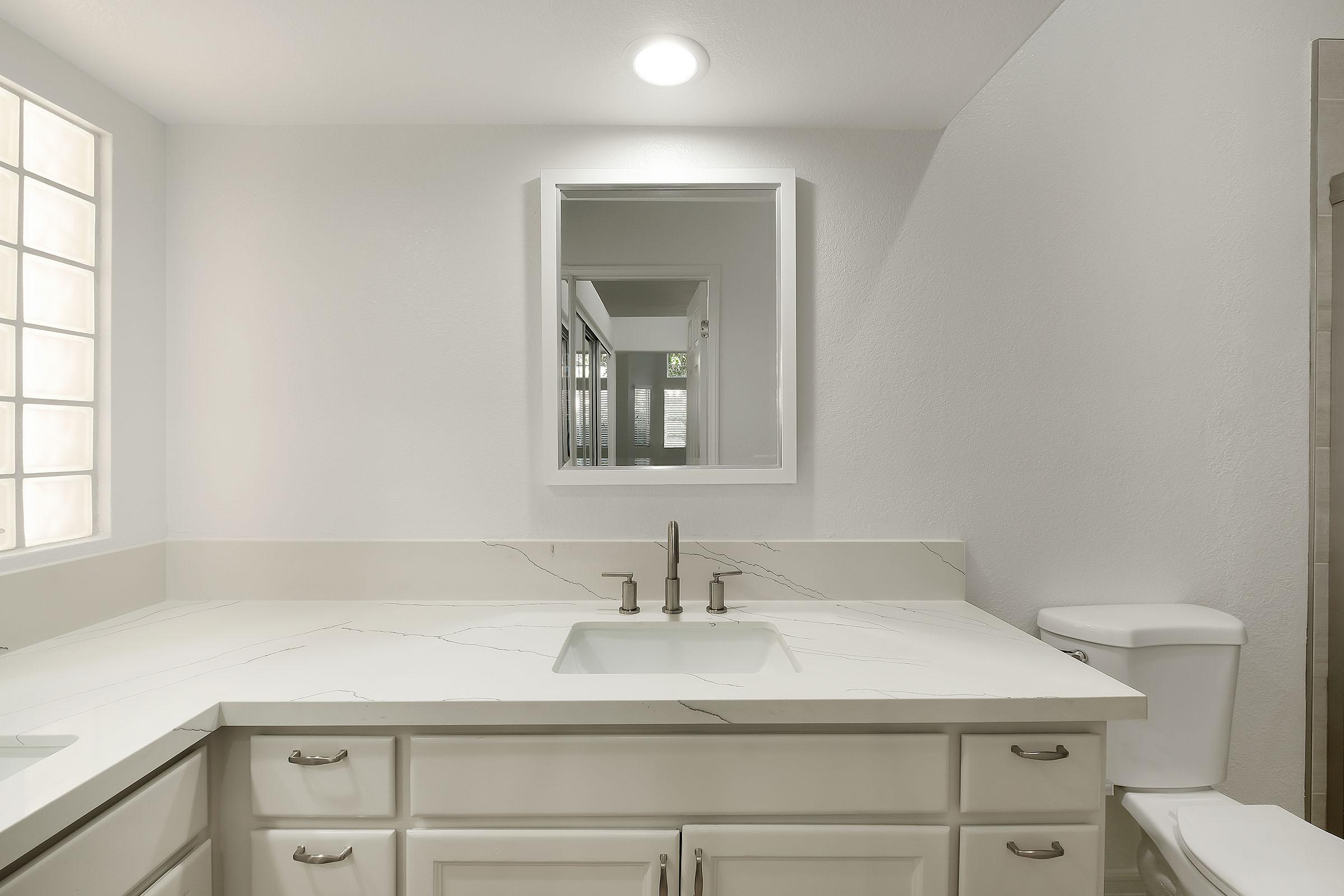 a kitchen with a sink and a mirror