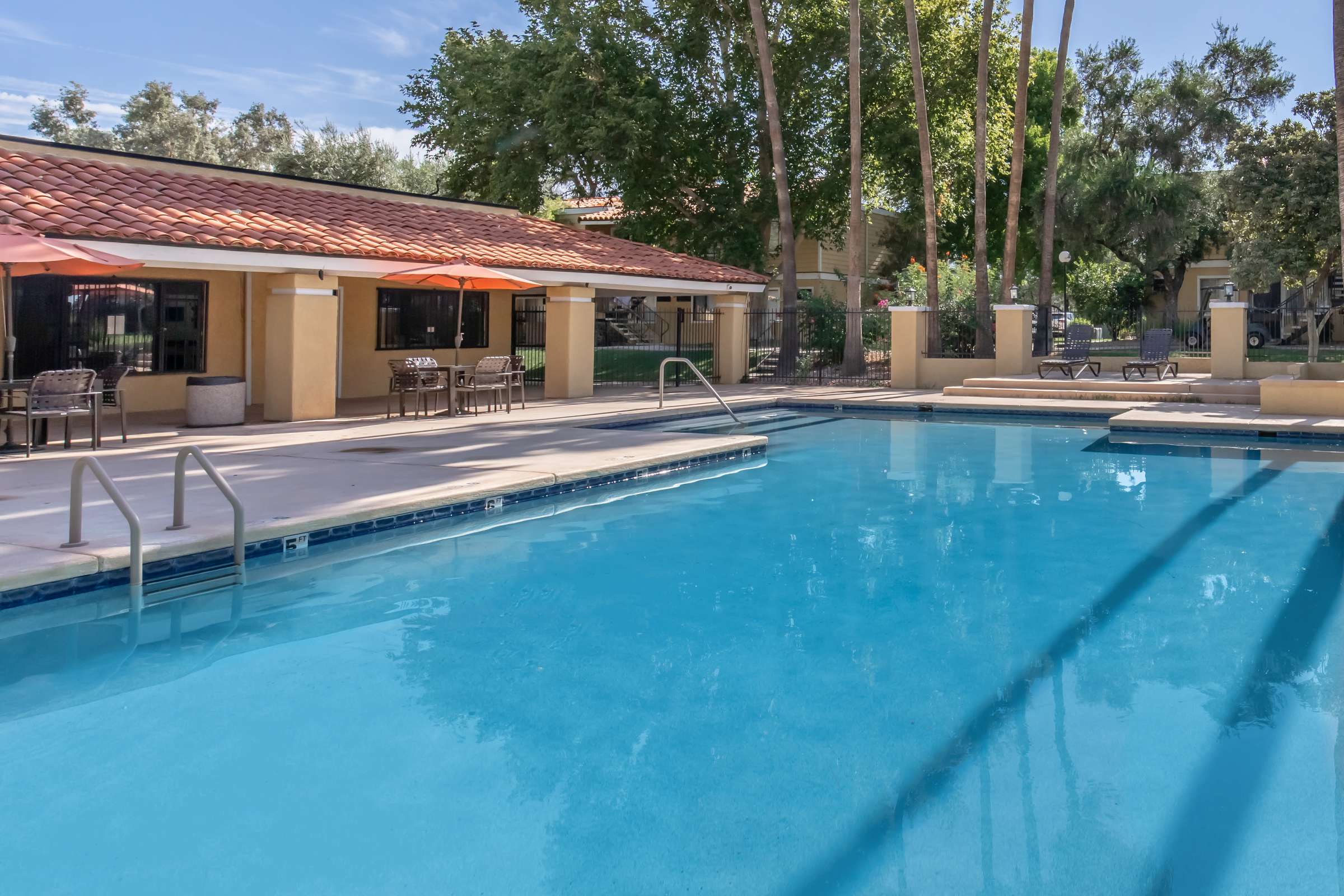 Pool beside landscaped grounds and community buildings.