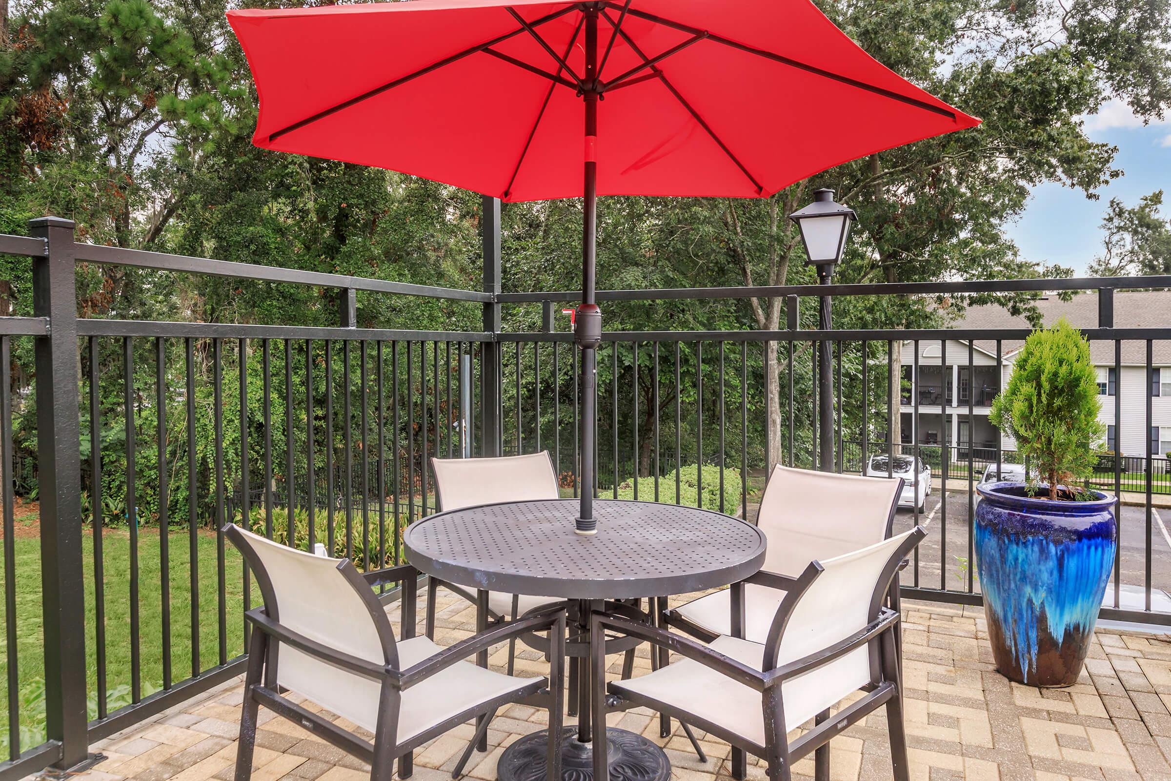 a group of lawn chairs sitting on top of a table umbrella