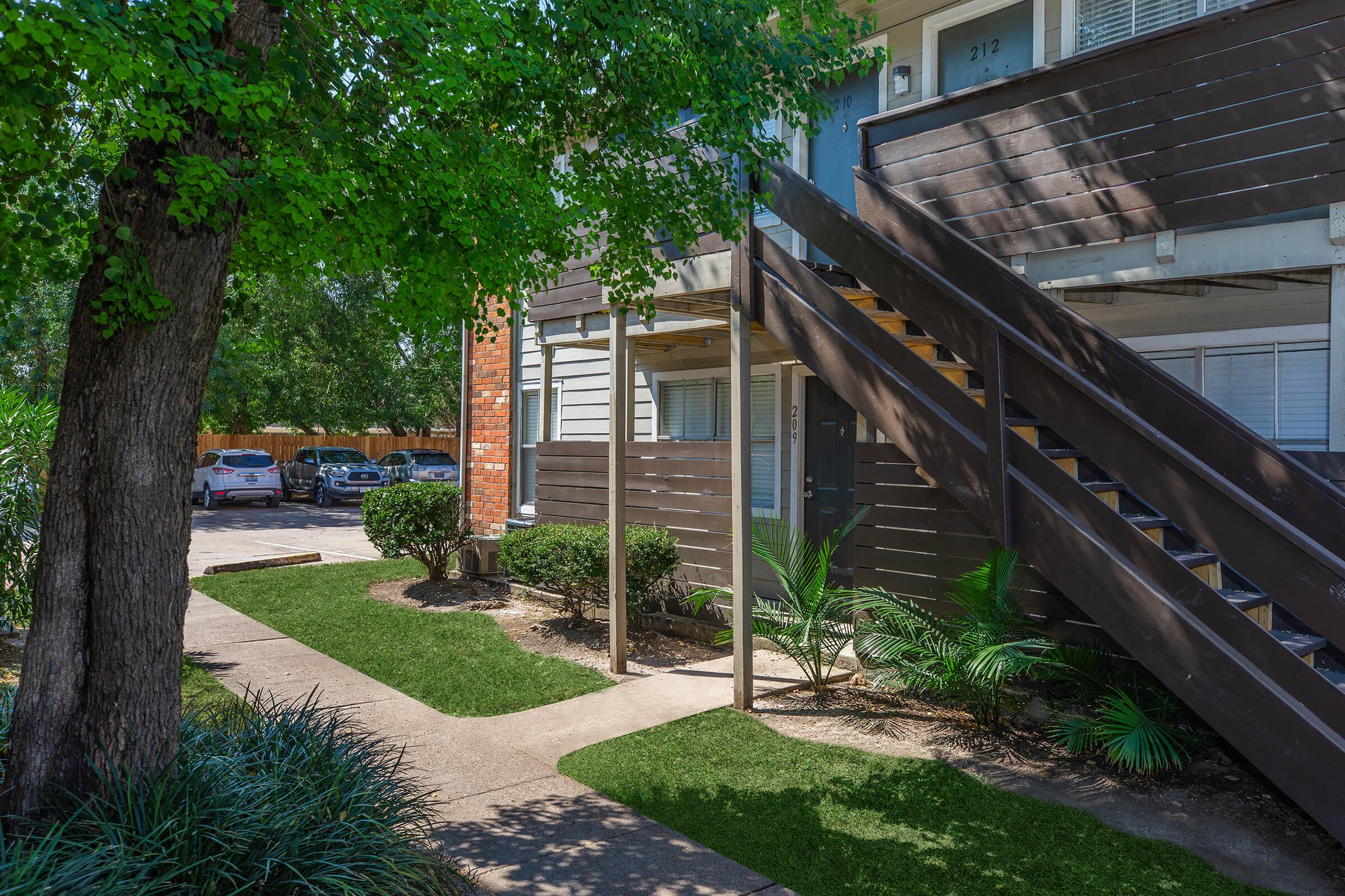 a path with trees on the side of a building