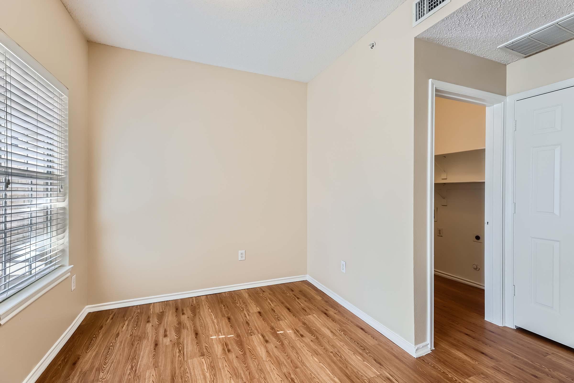 A small bedroom with a closet and wood-style flooring at Rise Skyline. 