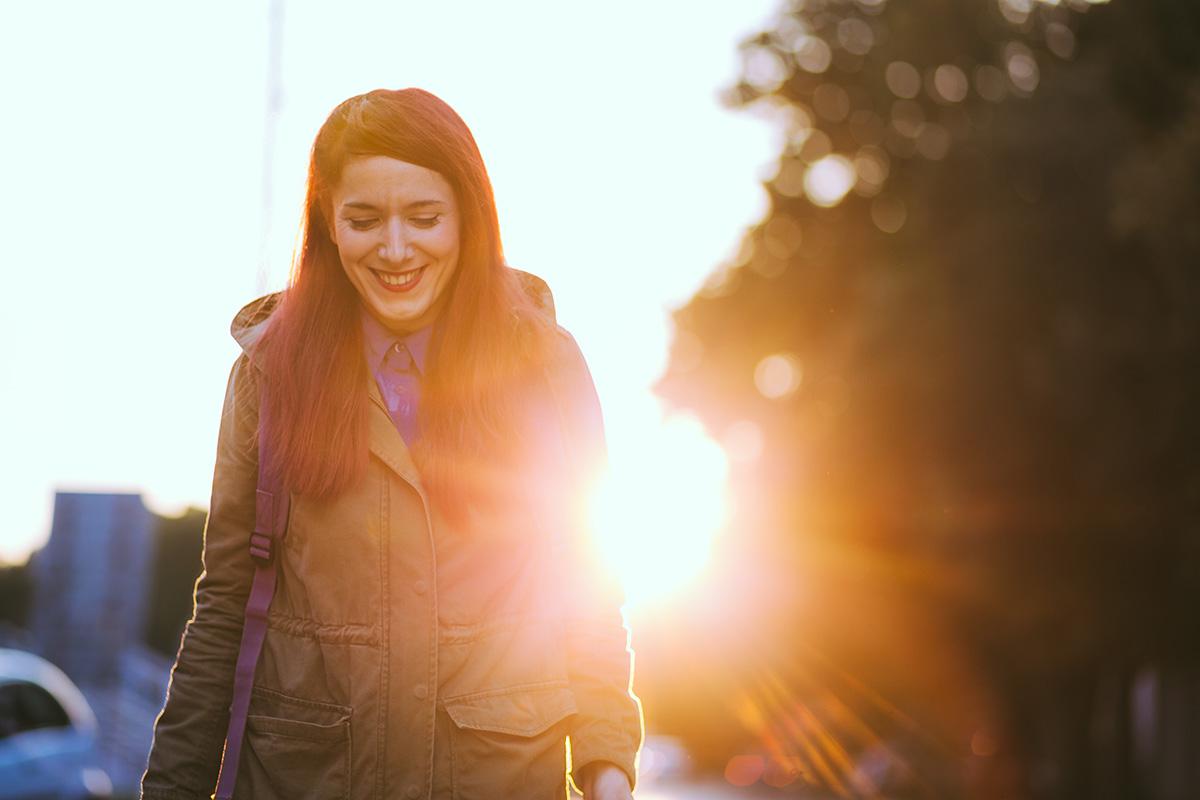 a woman standing in front of the sun