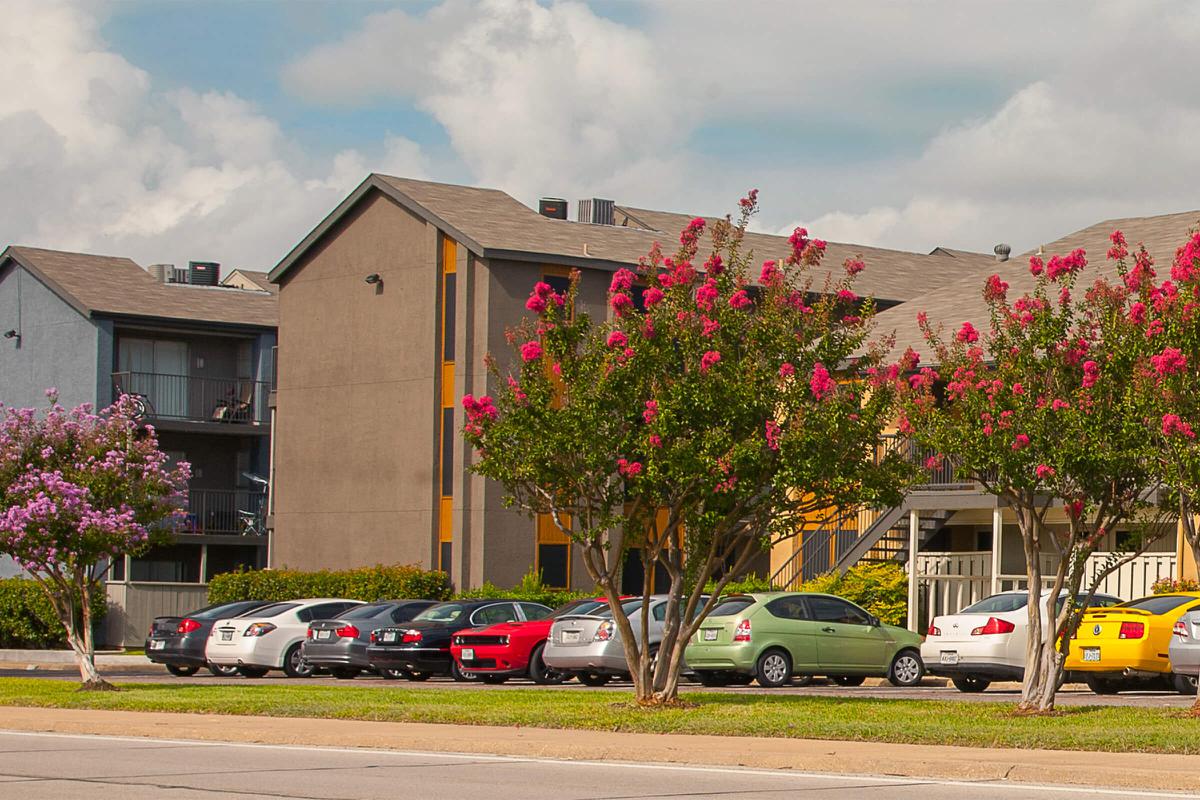 The Way Apartments community buildings with red flowers