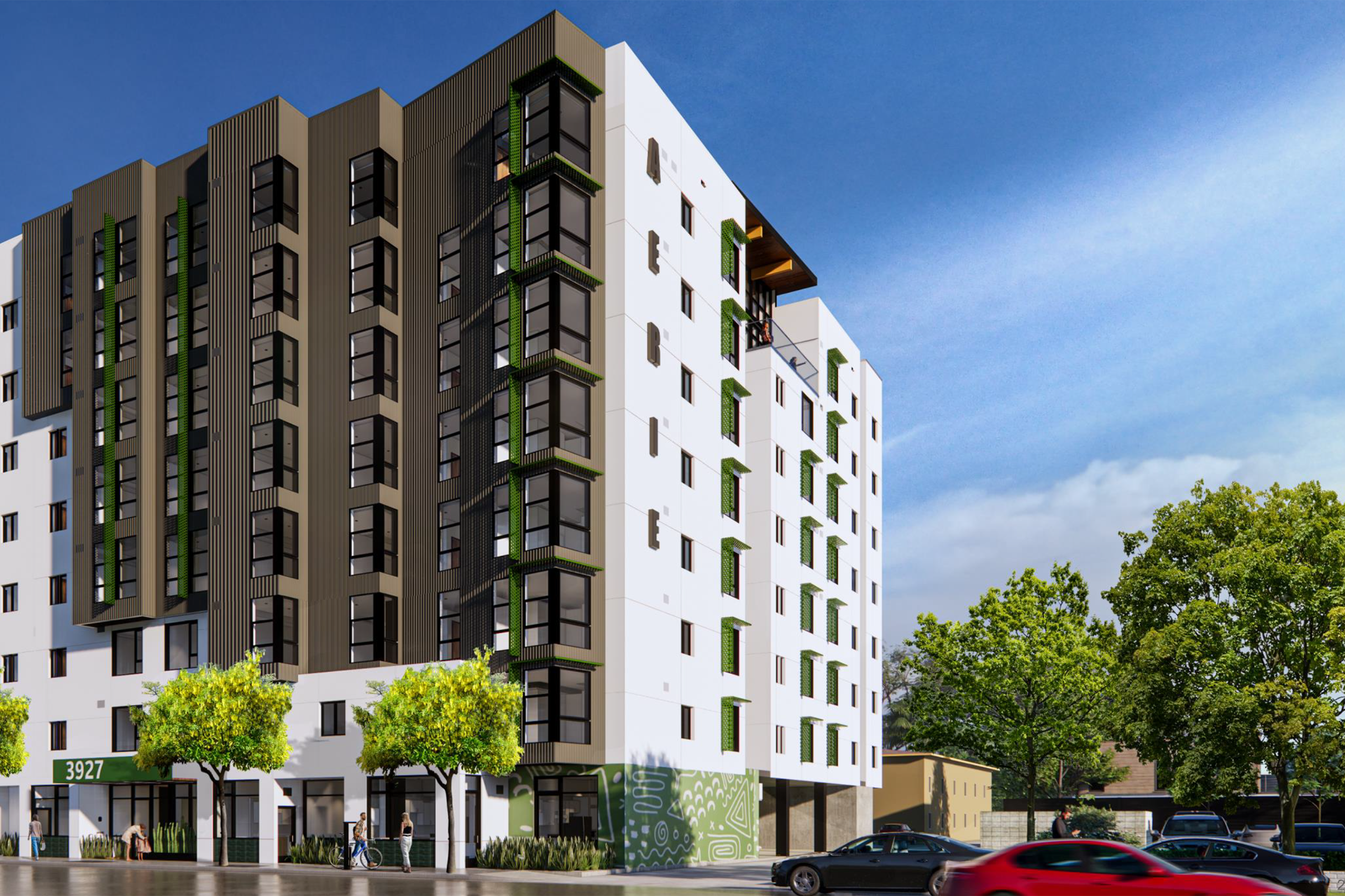 Modern multi-story residential building with white and dark green facade, featuring large windows and greenery at the base. Clear blue sky and a few trees are in the foreground, while a red car is driving past on the street. The building has a contemporary architectural design.