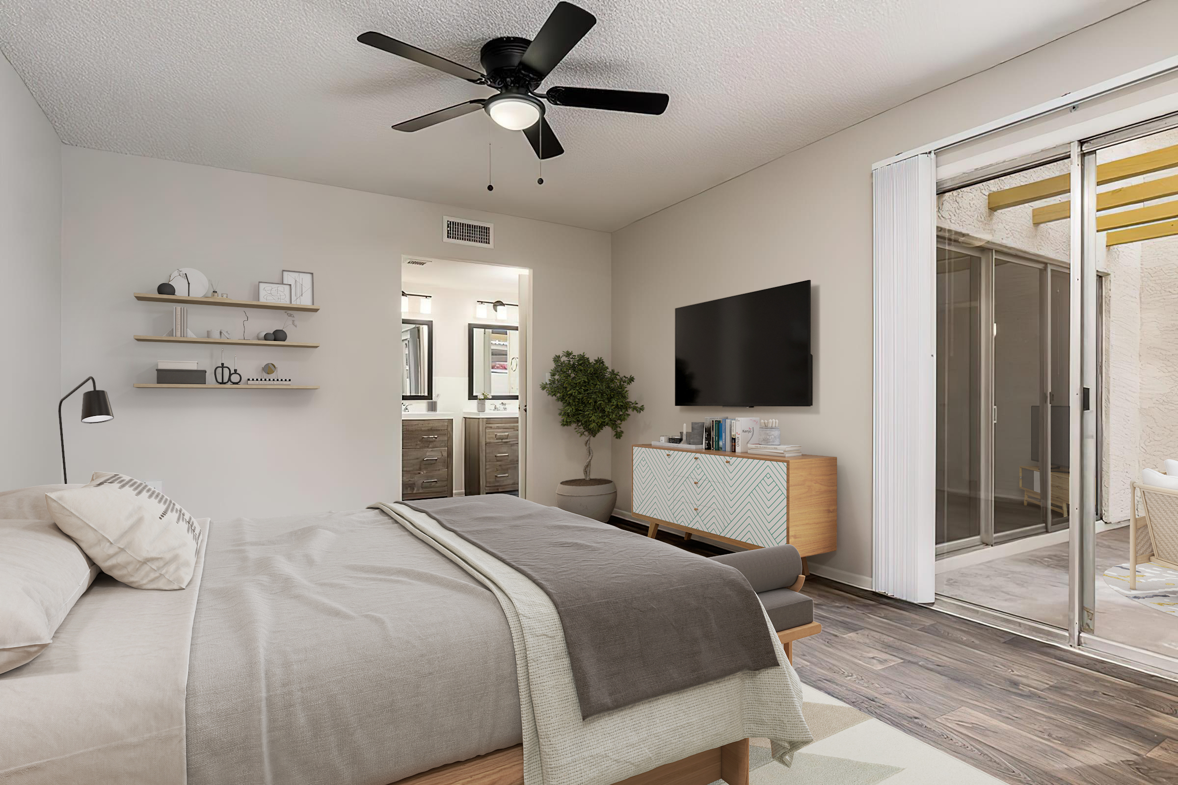 A modern bedroom featuring a queen-sized bed with neutral bedding, a ceiling fan, and wooden flooring. One wall has a mounted TV and a stylish media console. A large sliding door leads to an outdoor area, while a bathroom with dual sinks is visible through an open doorway. Decorative shelves and a potted plant add to the ambiance.