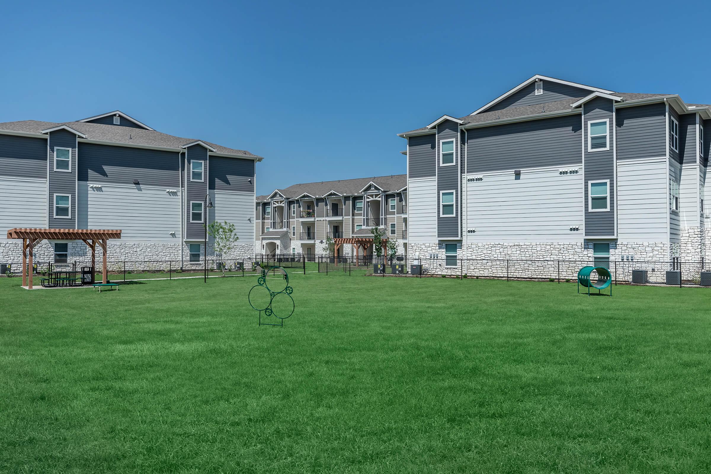 a large green field in front of a house