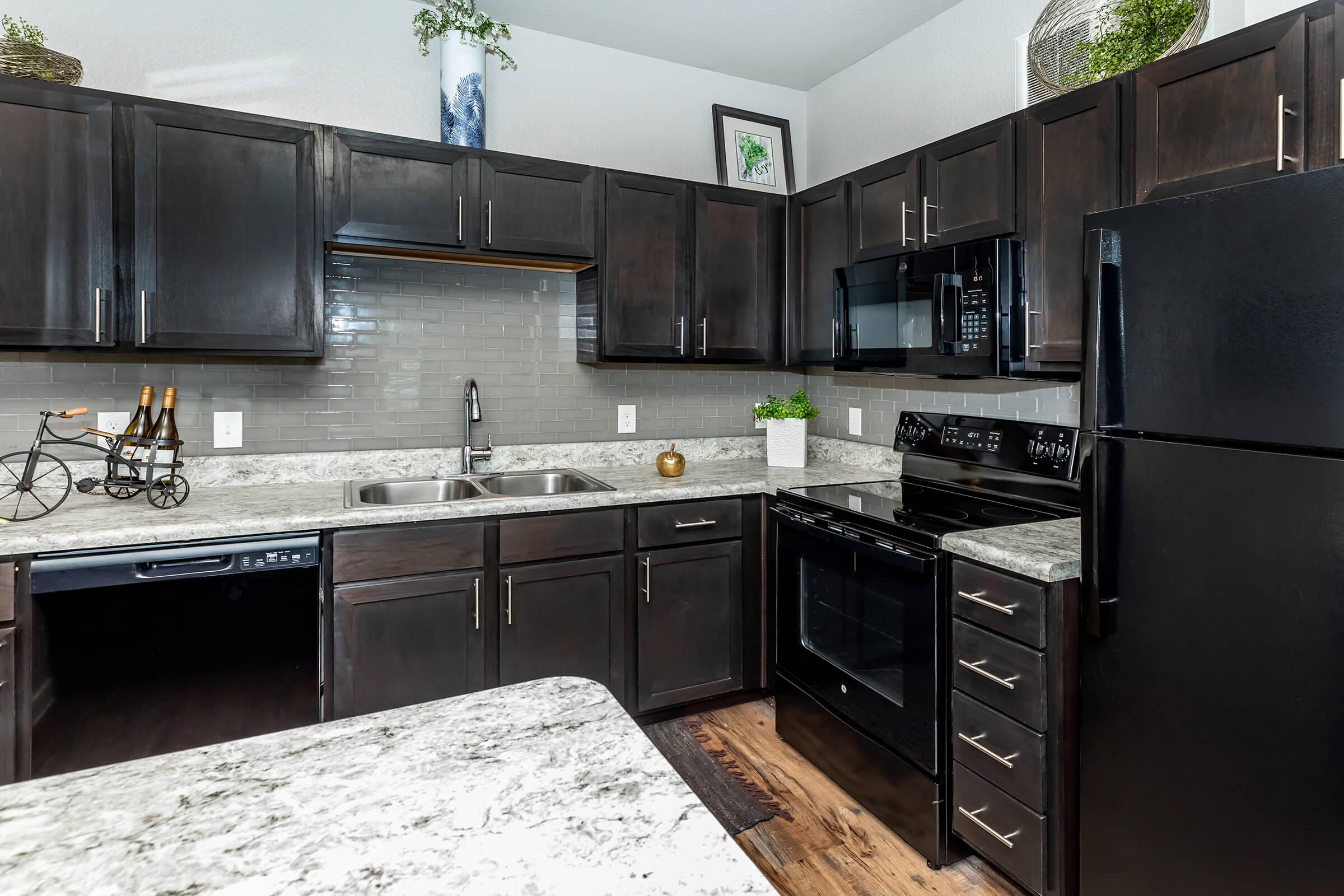 a large kitchen with stainless steel appliances and wooden cabinets