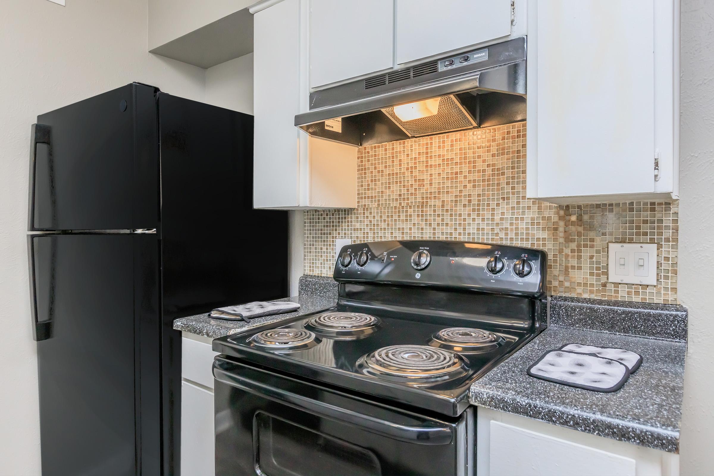 a stove top oven sitting inside of a kitchen