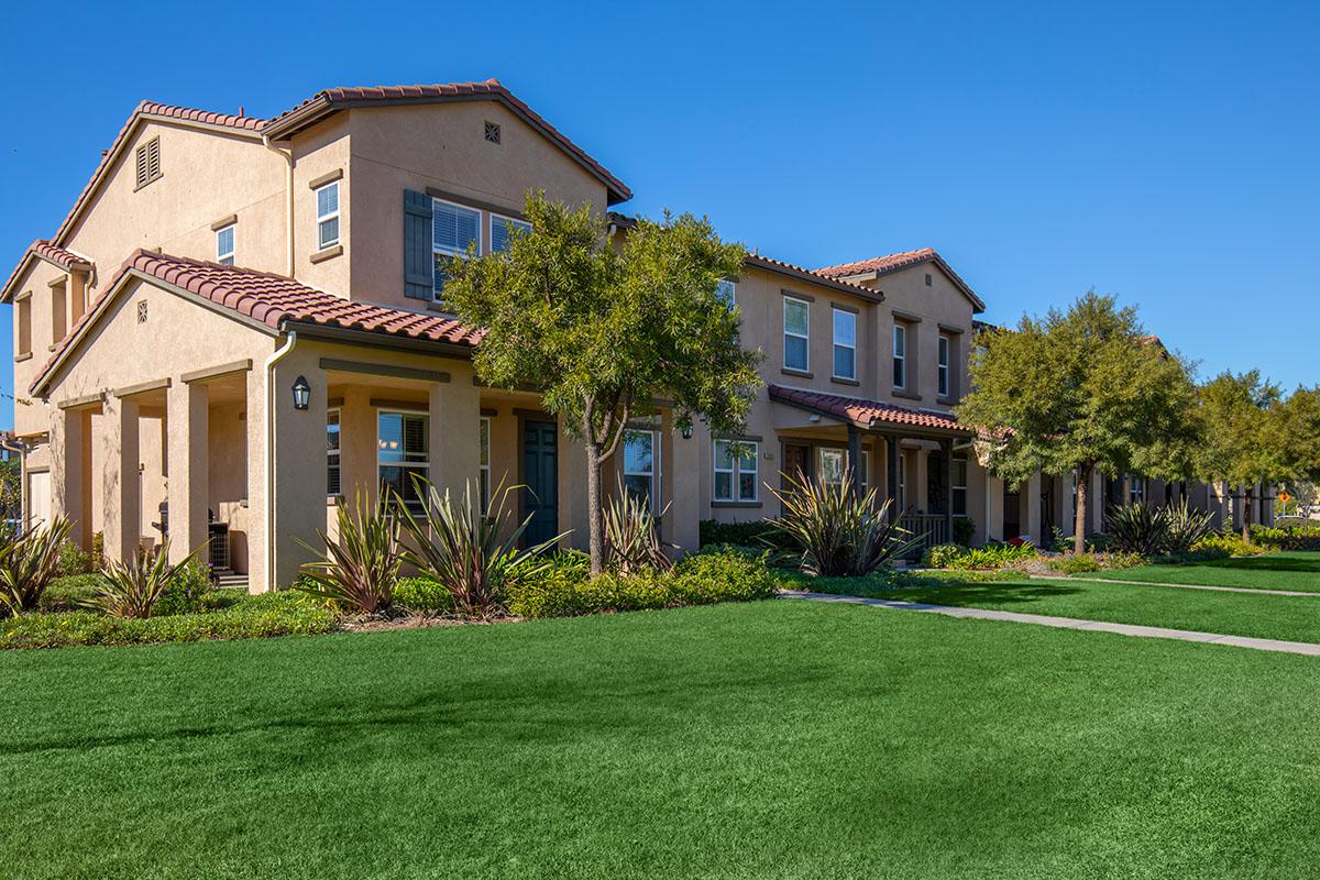 a house with a lawn in front of a brick building