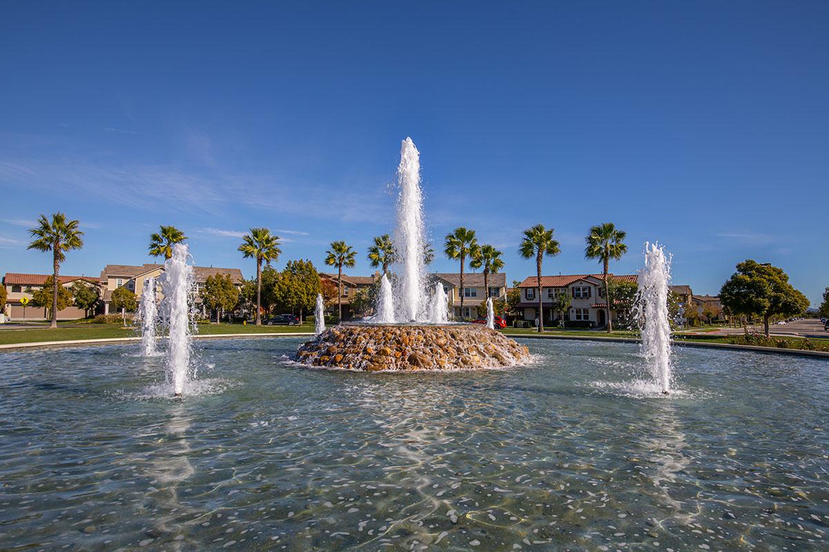 a fountain in front of a body of water